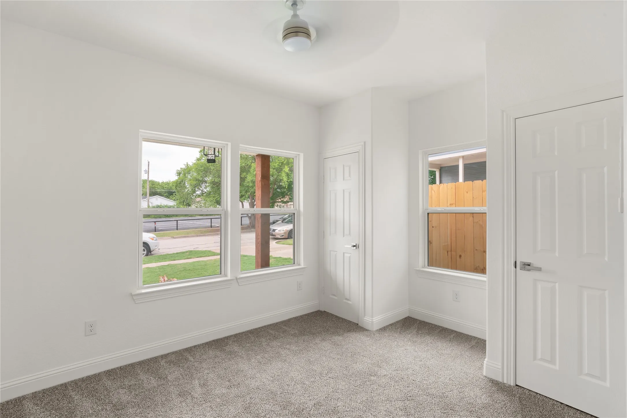 Neutral-toned carpeting, white baseboards, and white painted walls