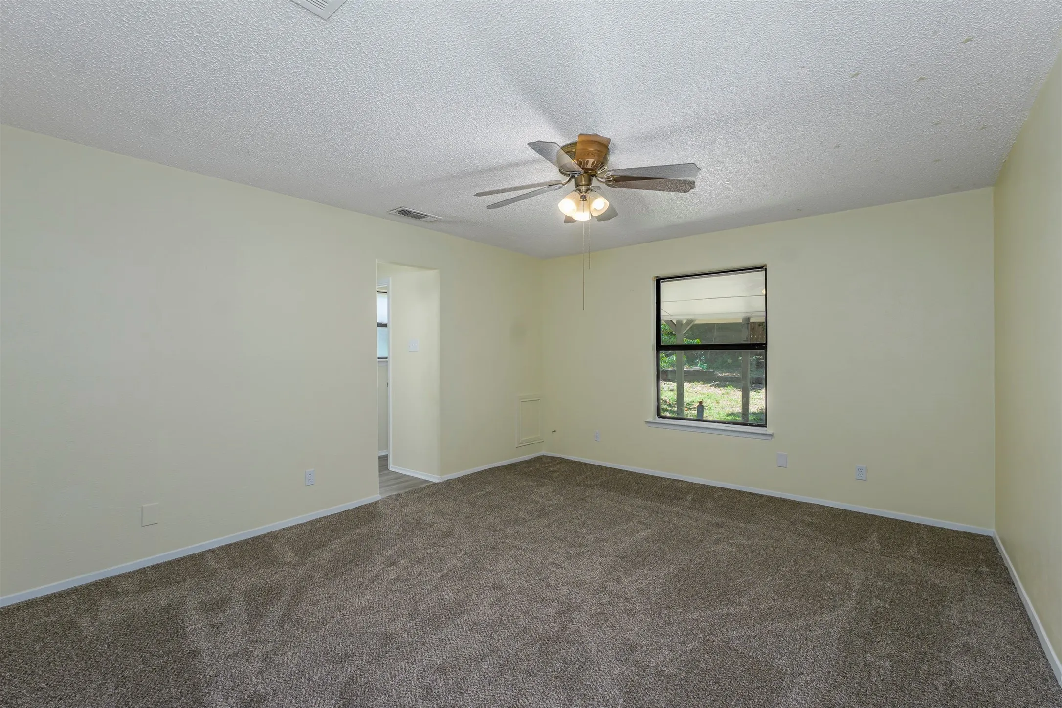 Carpeted room featuring a ceiling fan with integrated lighting, a window with blinds, and light-toned wall finishes