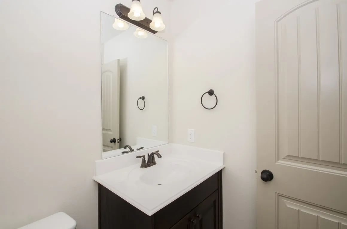 Bathroom vanity featuring a white countertop, an integrated sink, and an oil-rubbed bronze faucet