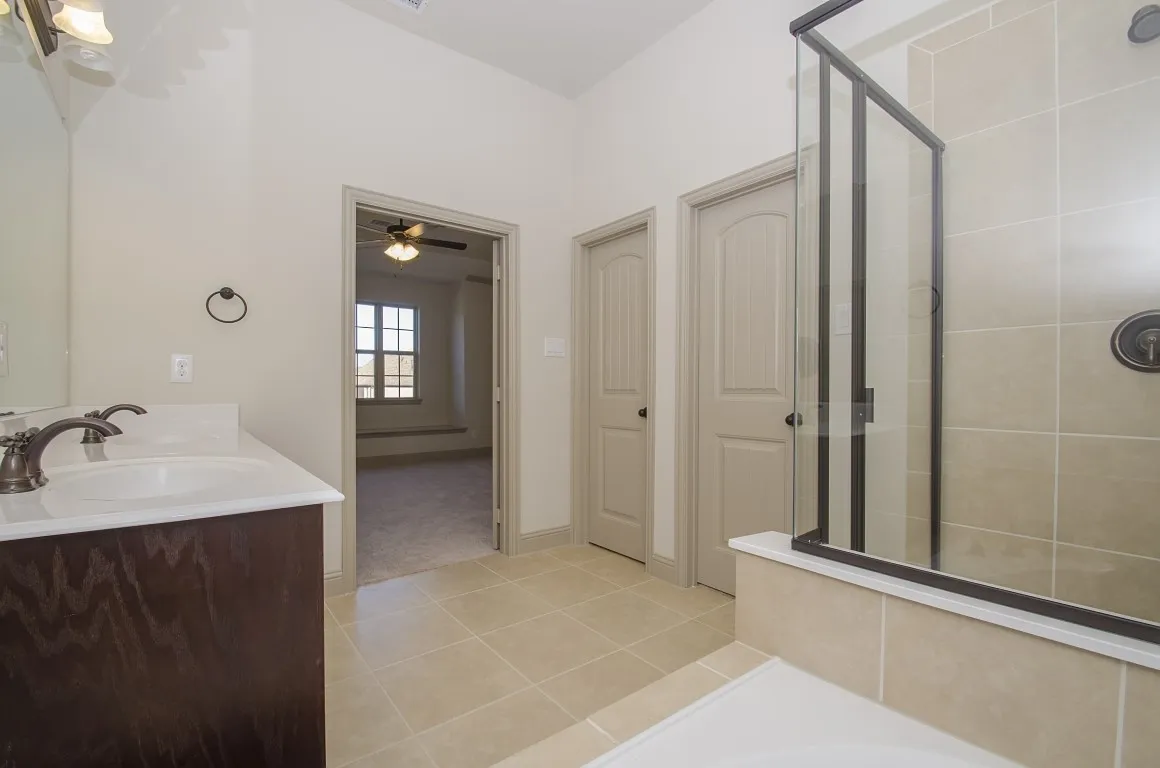 Bathroom with a dark wood-finish vanity, white countertop, and dual sinks
