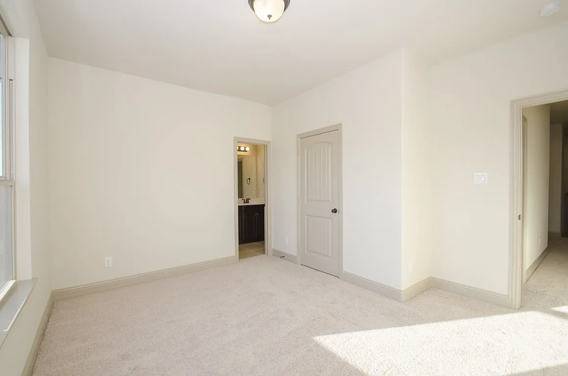 Carpeted room with neutral wall tones and base molding