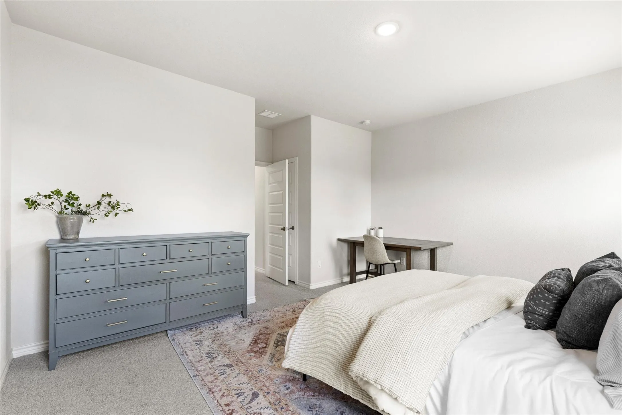 Carpeted bedroom featuring white walls, a recessed ceiling light, and a paneled door