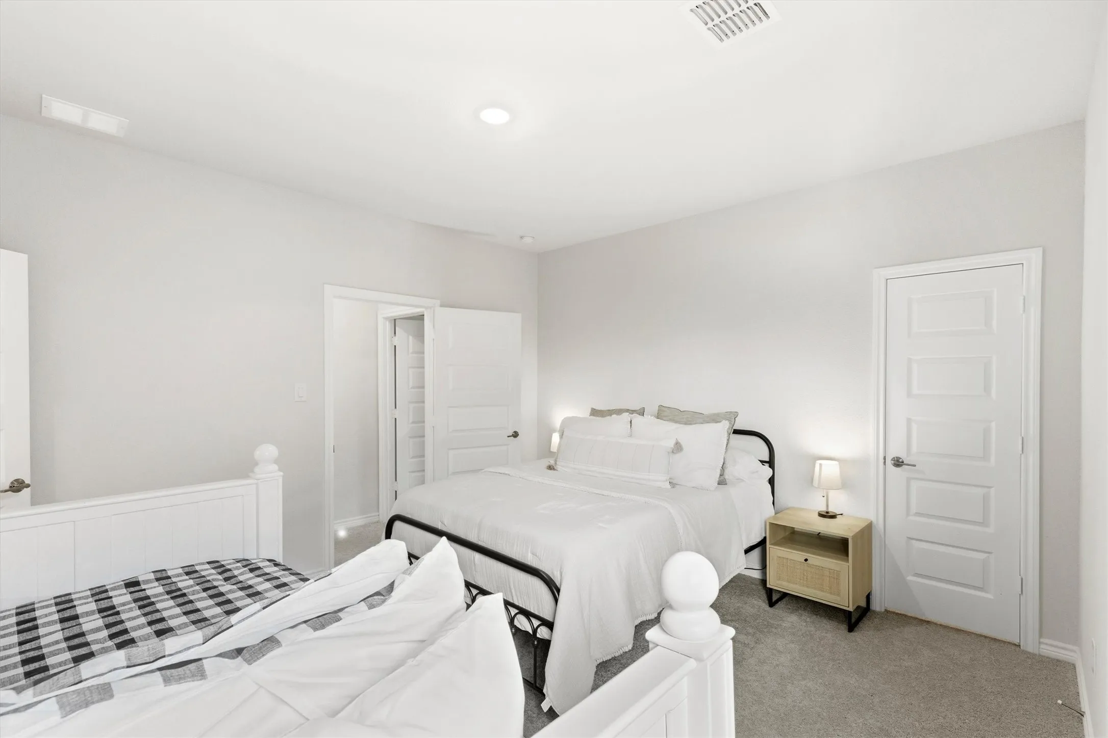 Carpeted room with light neutral wall tones, recessed lighting, and white paneled doors