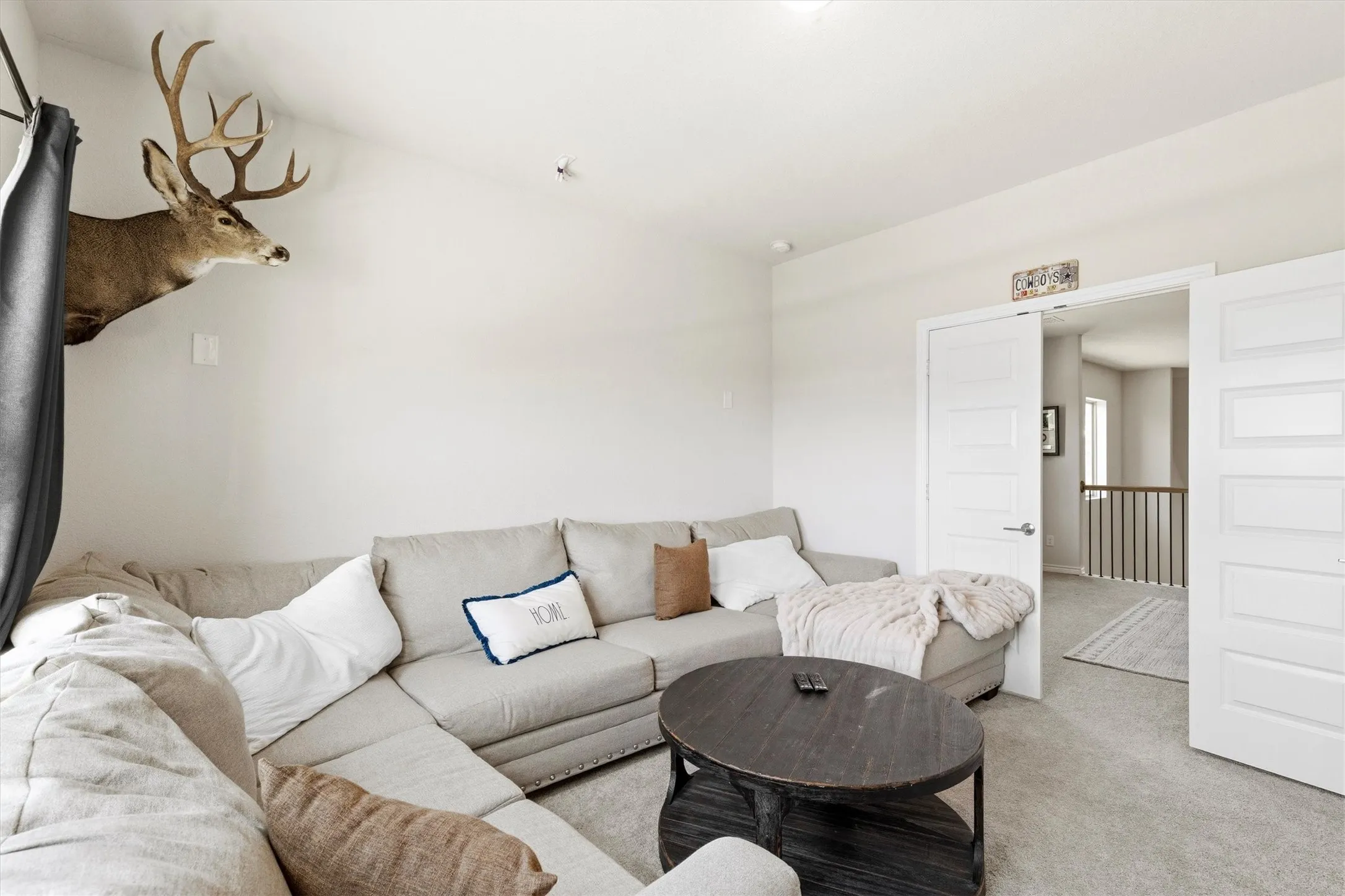 Carpeted room with a recessed light, white walls, and a white paneled door