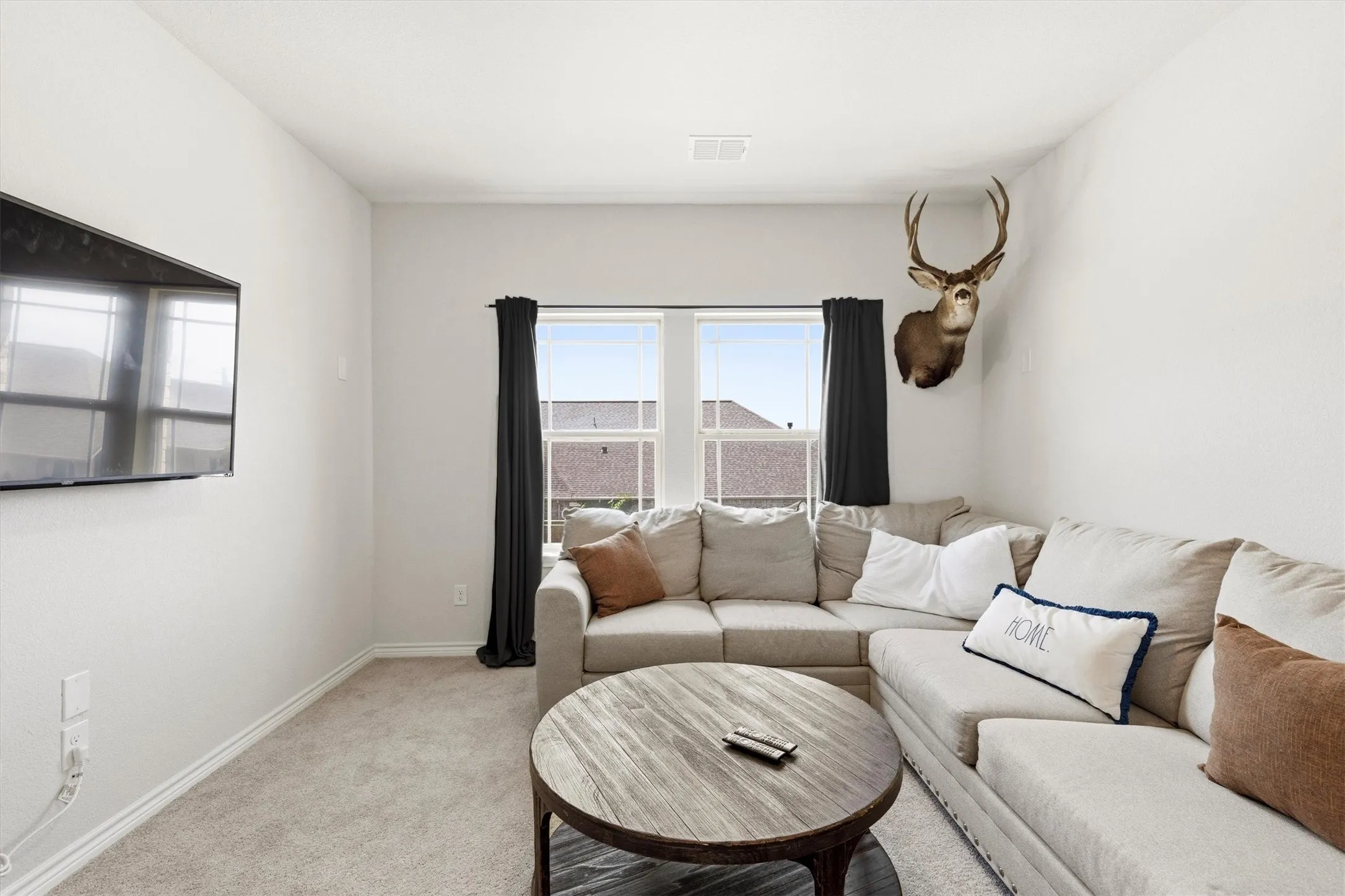 Carpeted room with white walls, baseboards, and window trim