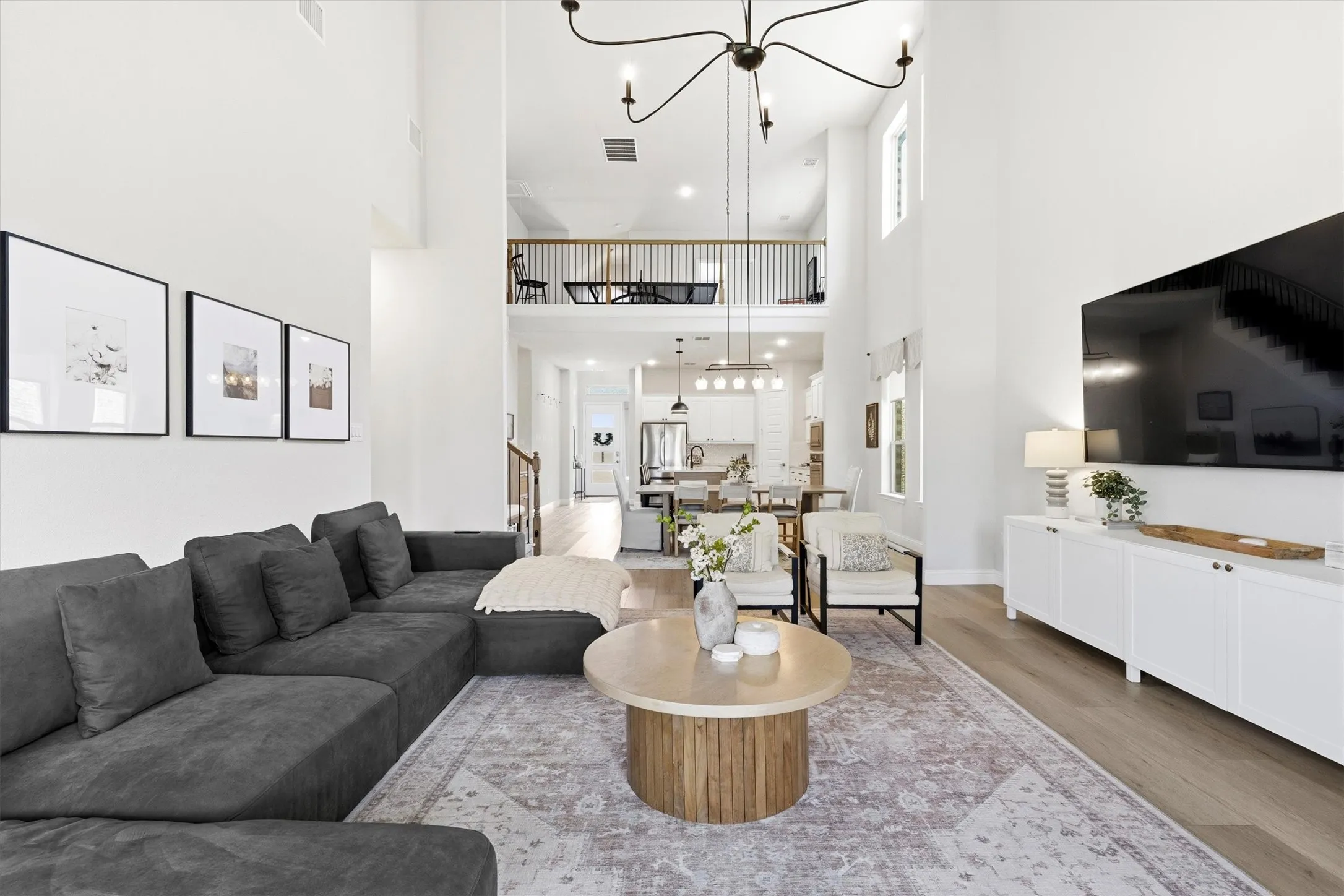 Spacious living area featuring high ceilings, wood-finish flooring, and an open-concept design