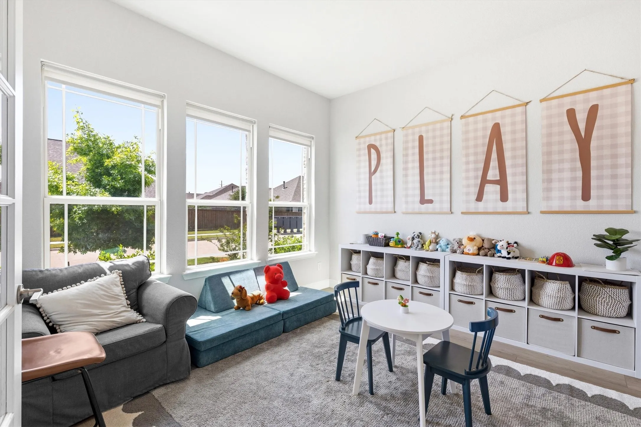 Bright room featuring three large windows, white walls, and light-colored flooring