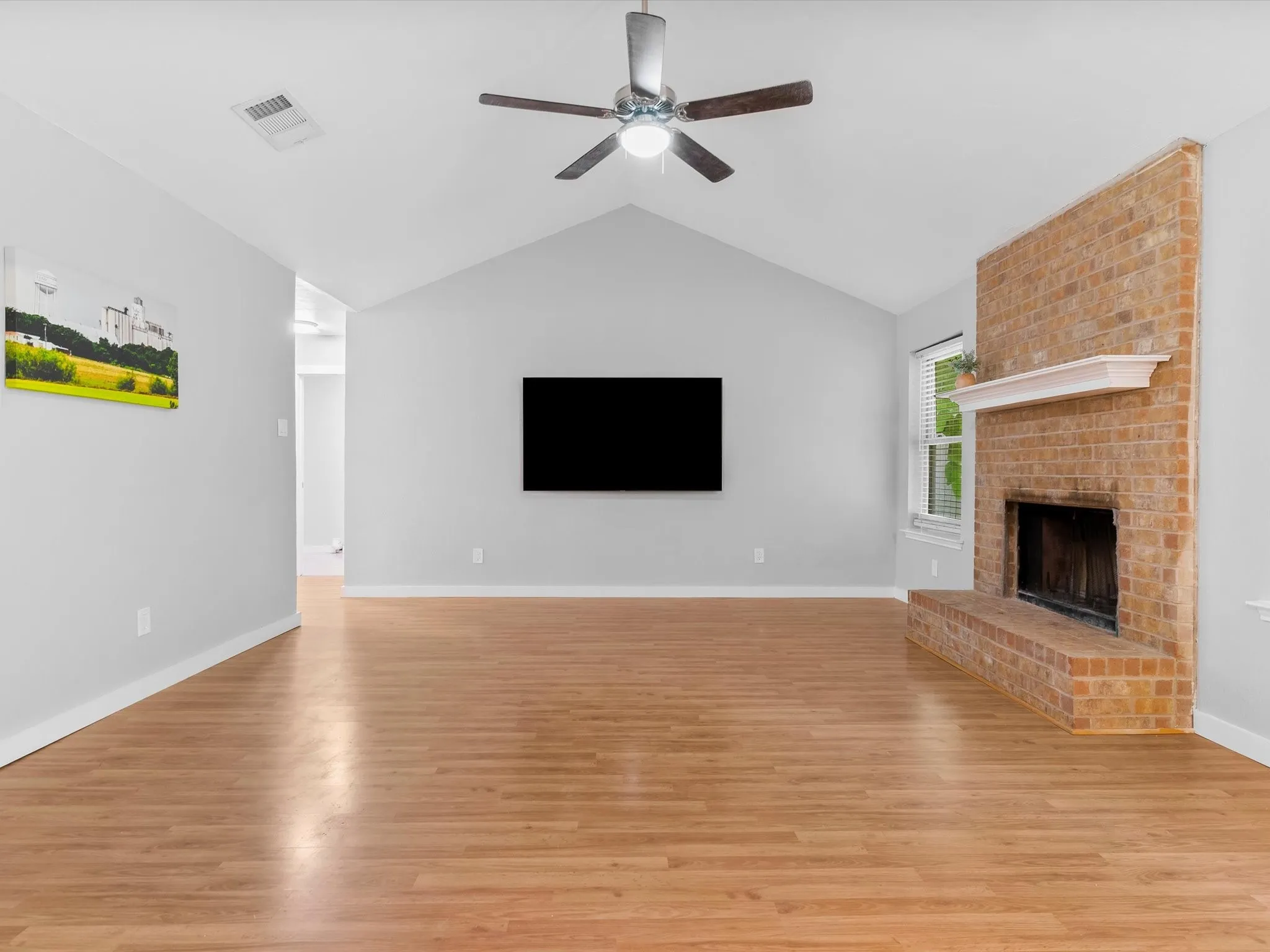 Spacious living room with vaulted ceiling, abundant natural light, and open layout.