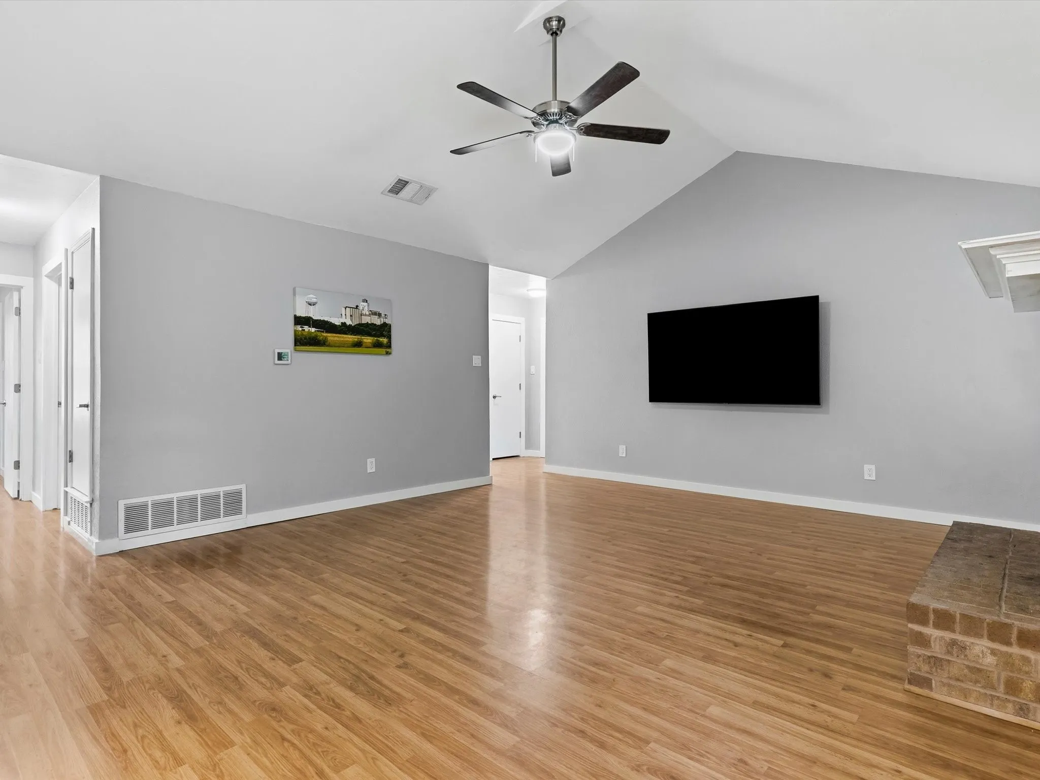 Spacious living room with vaulted ceiling, abundant natural light, and open layout.