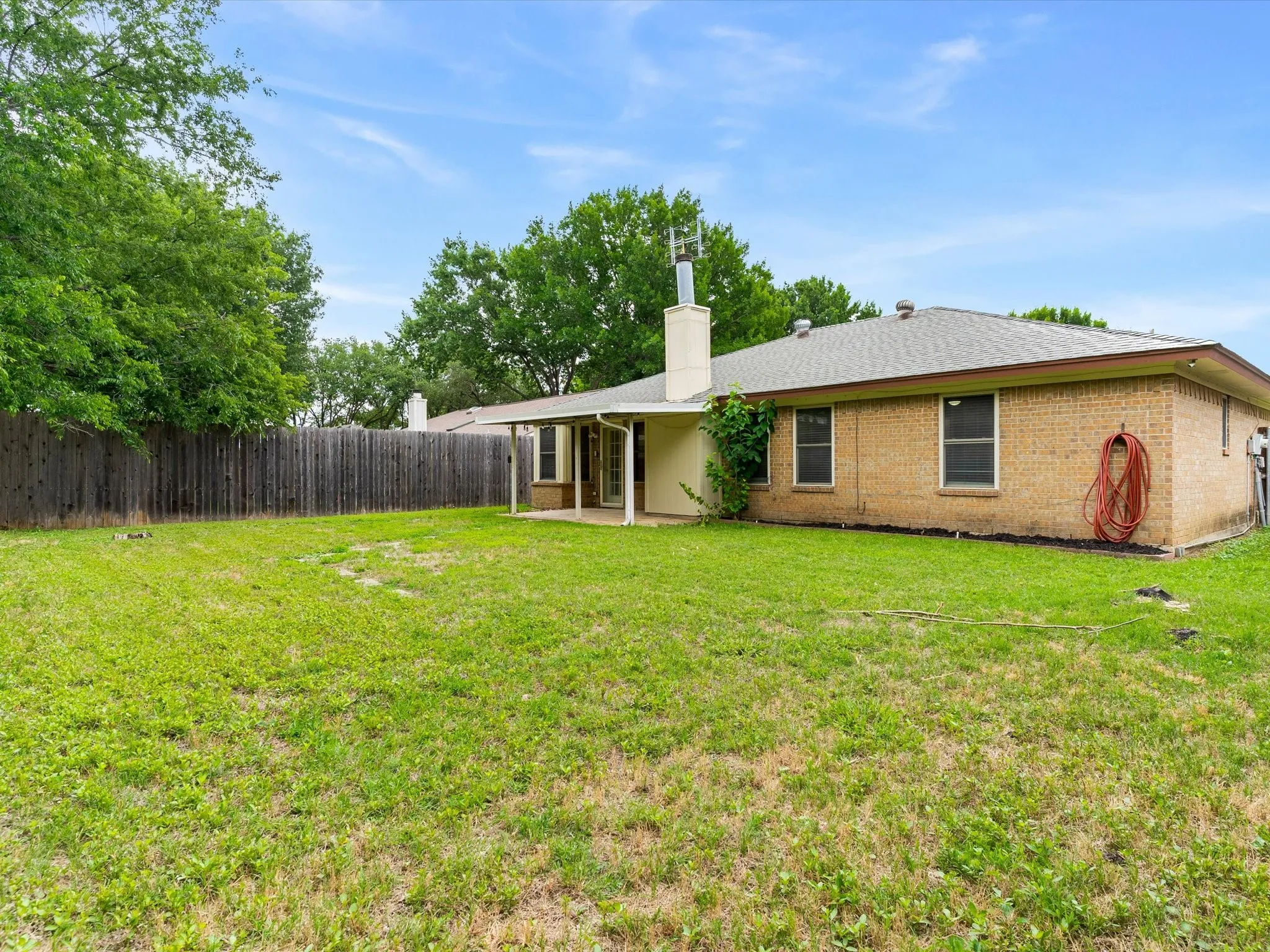 Backyard with open green space and room for pets, play, or gardening.