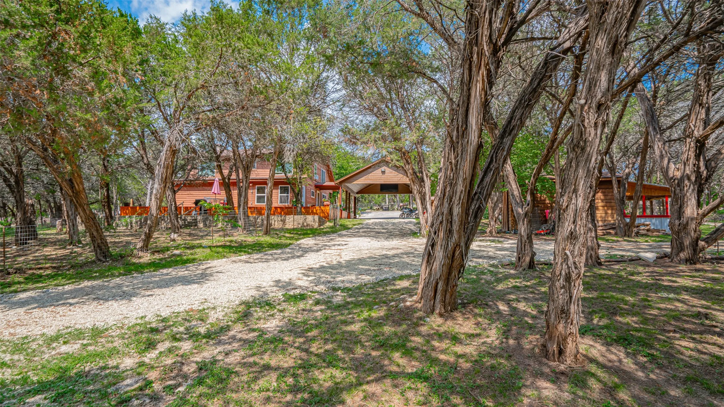 Back view of home, car port, and chicken coop