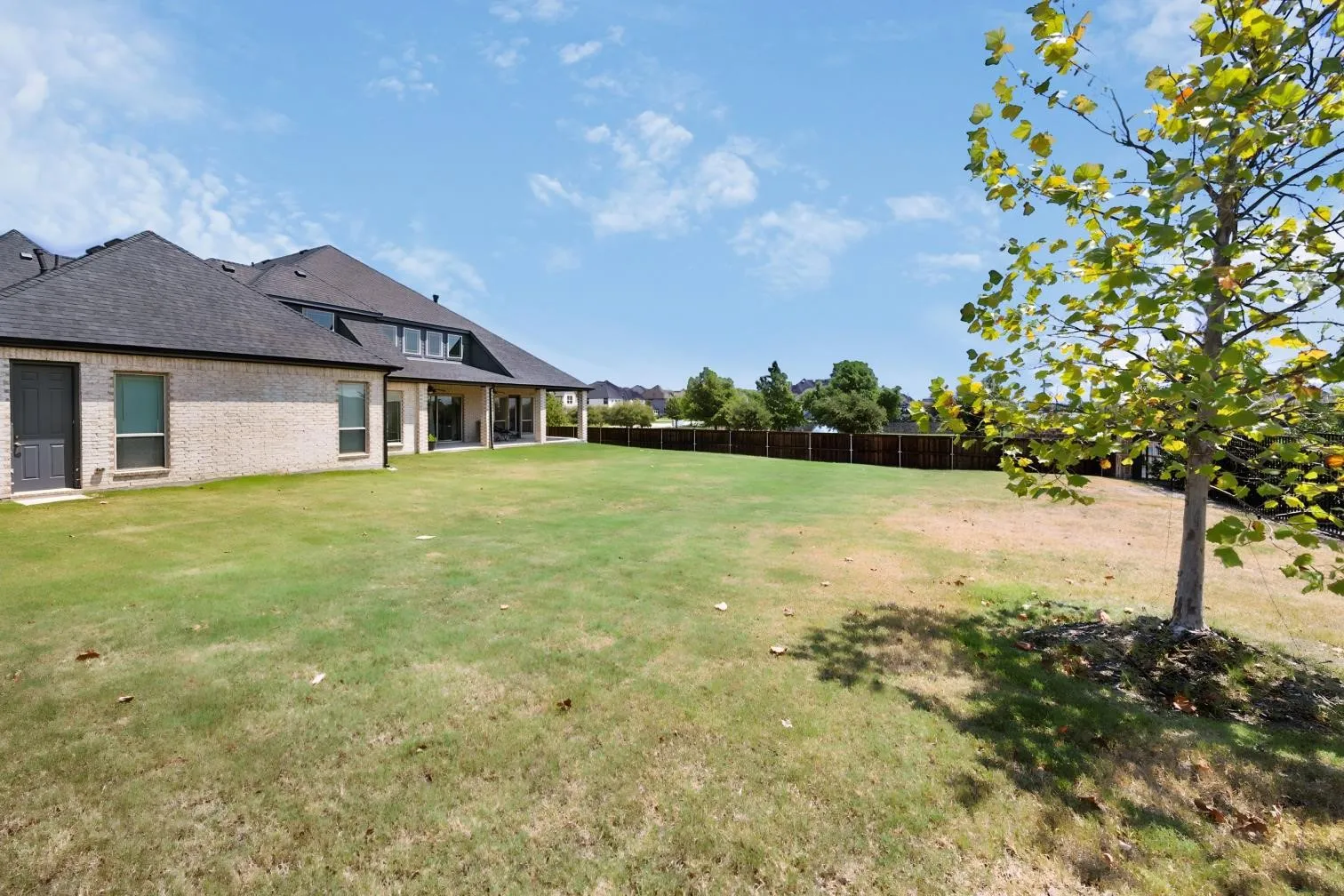 Huge backyard lined with trees on one side and fountain view on the other.