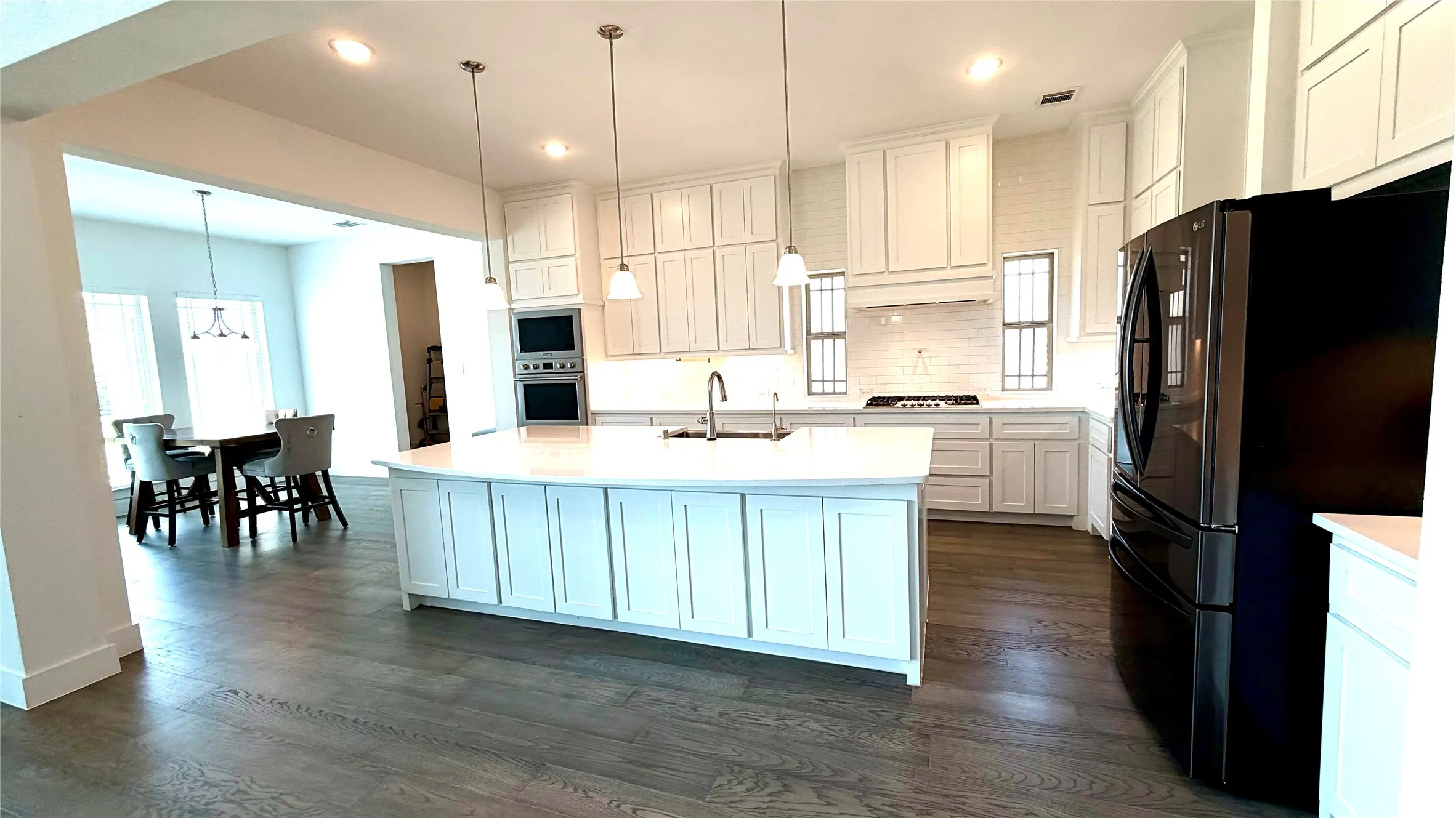 Kitchen with huge island, double oven, farmhouse SS sink and breakfast nook