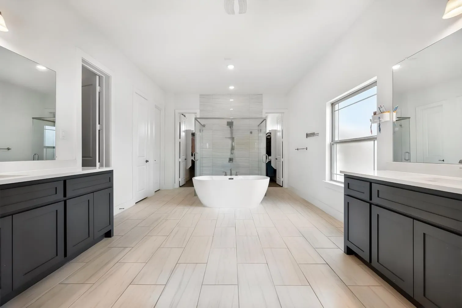 Primary Bathroom with separate vanities,  separate HIS & HER closets, free standing tub and walk in shower