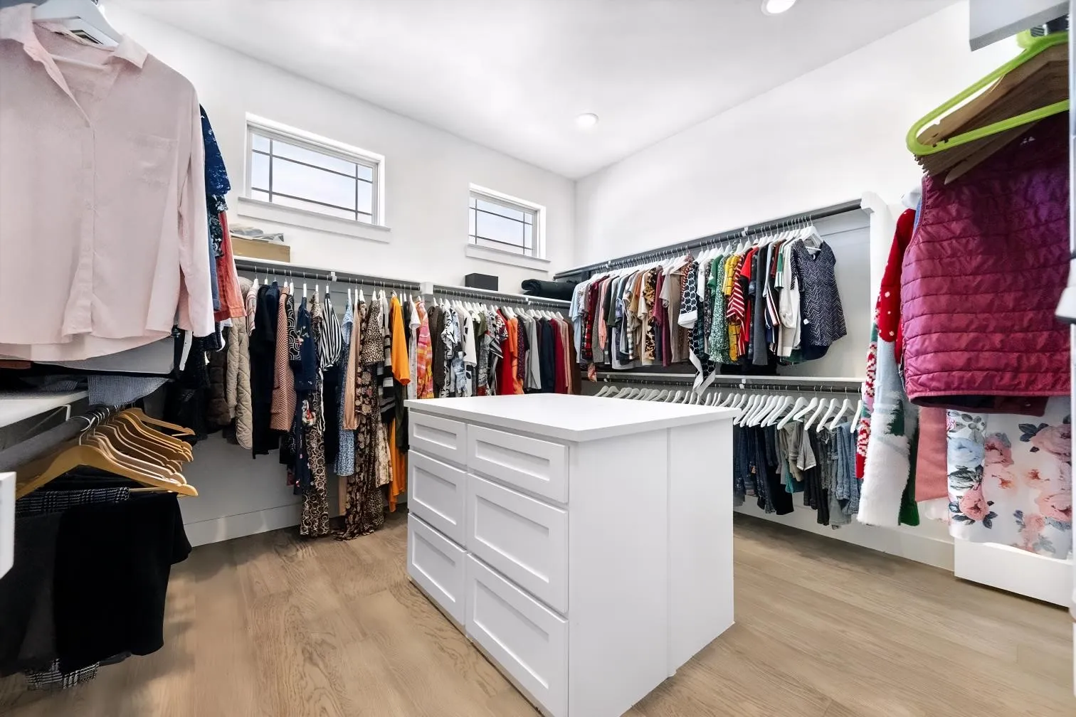 Dream closet for Her with center island, ample storage space and windows
