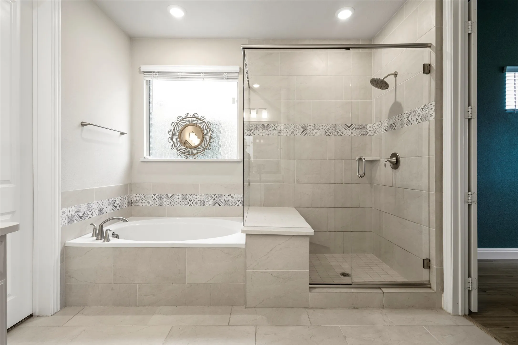 Bathroom featuring a built-in soaking tub with a tiled surround and a separate glass-enclosed shower