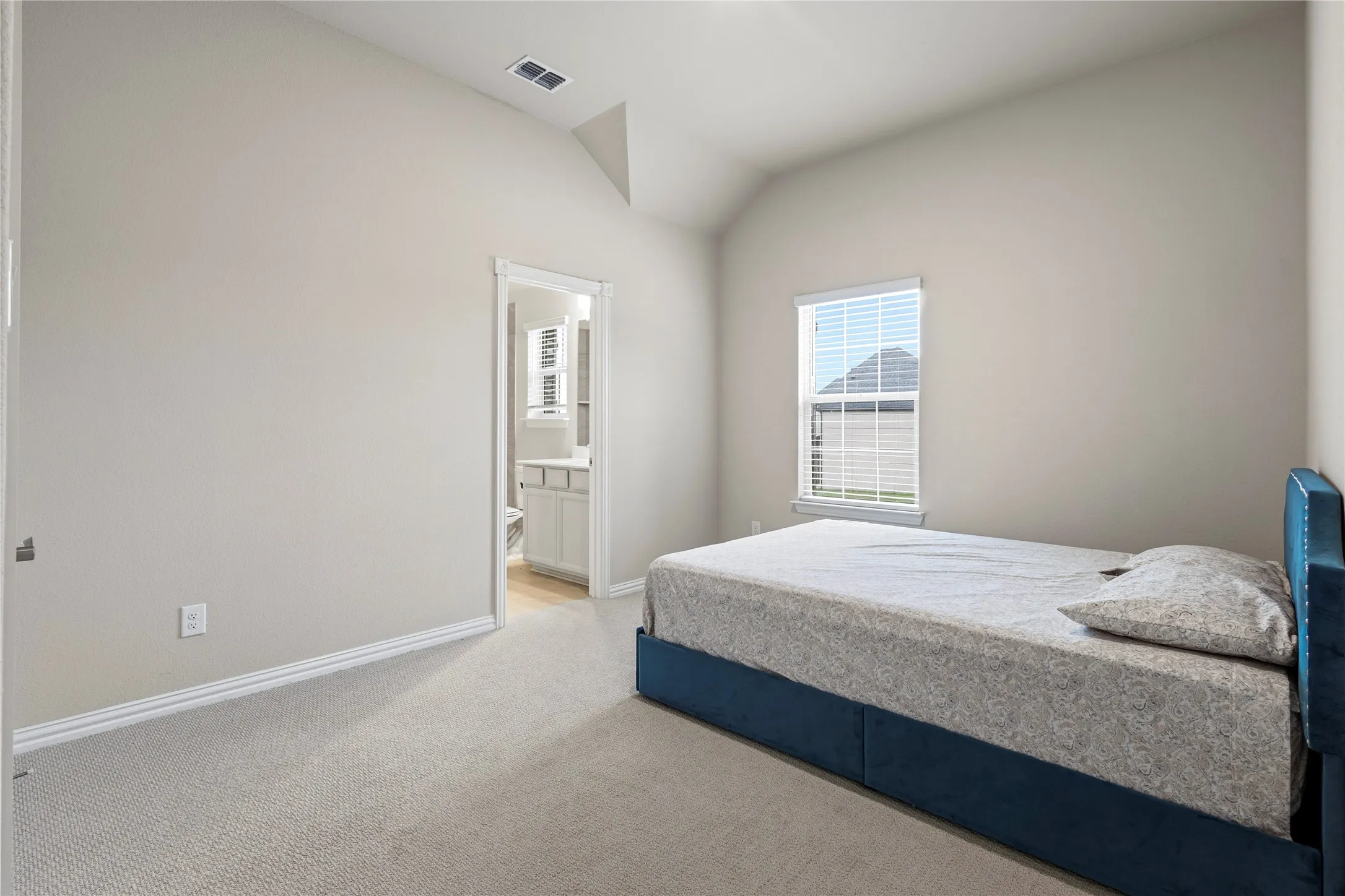 Carpeted room featuring a vaulted ceiling and a single window with blinds