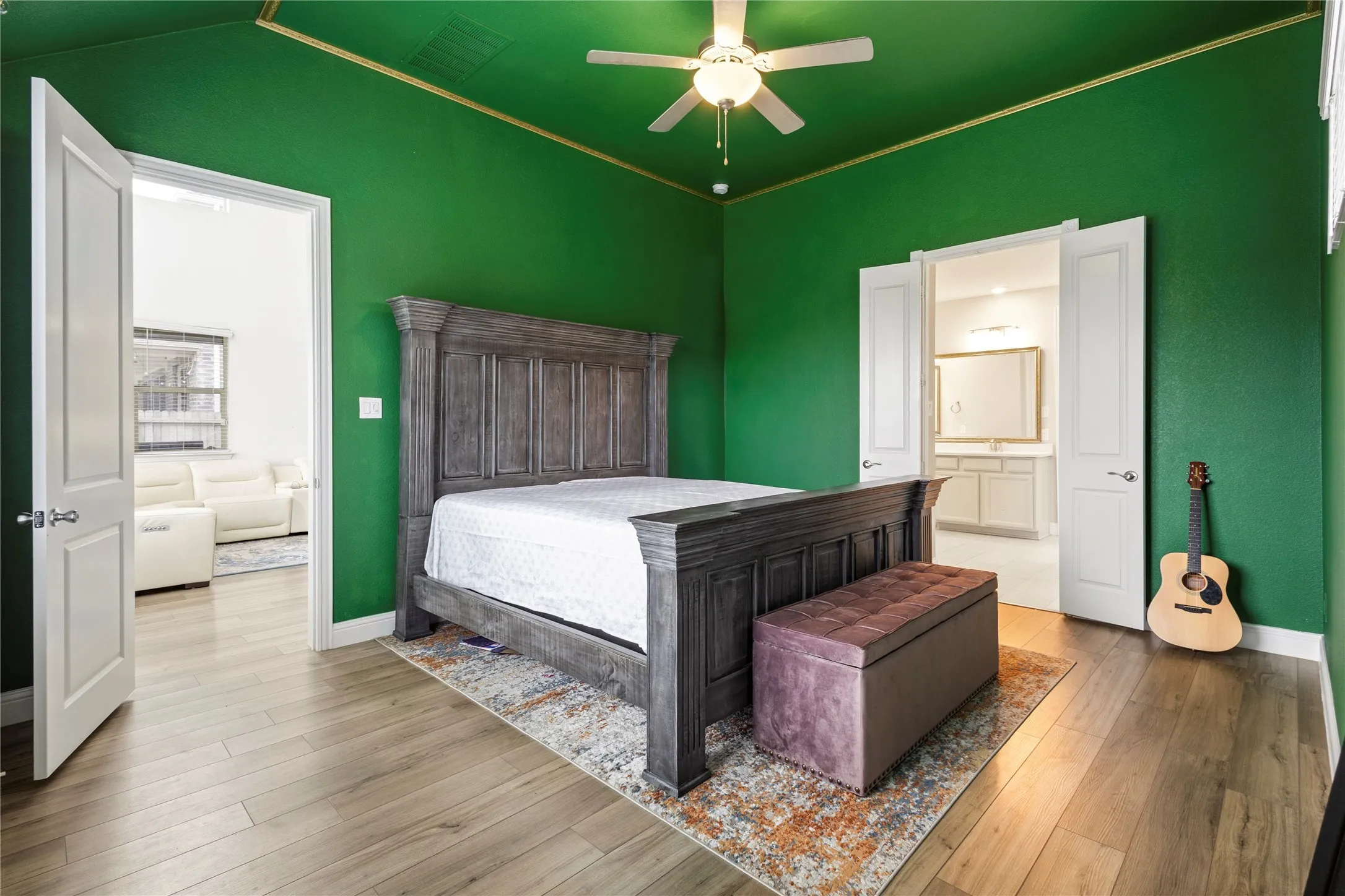 Bright green walls with a contrasting white trim and wood-finish flooring