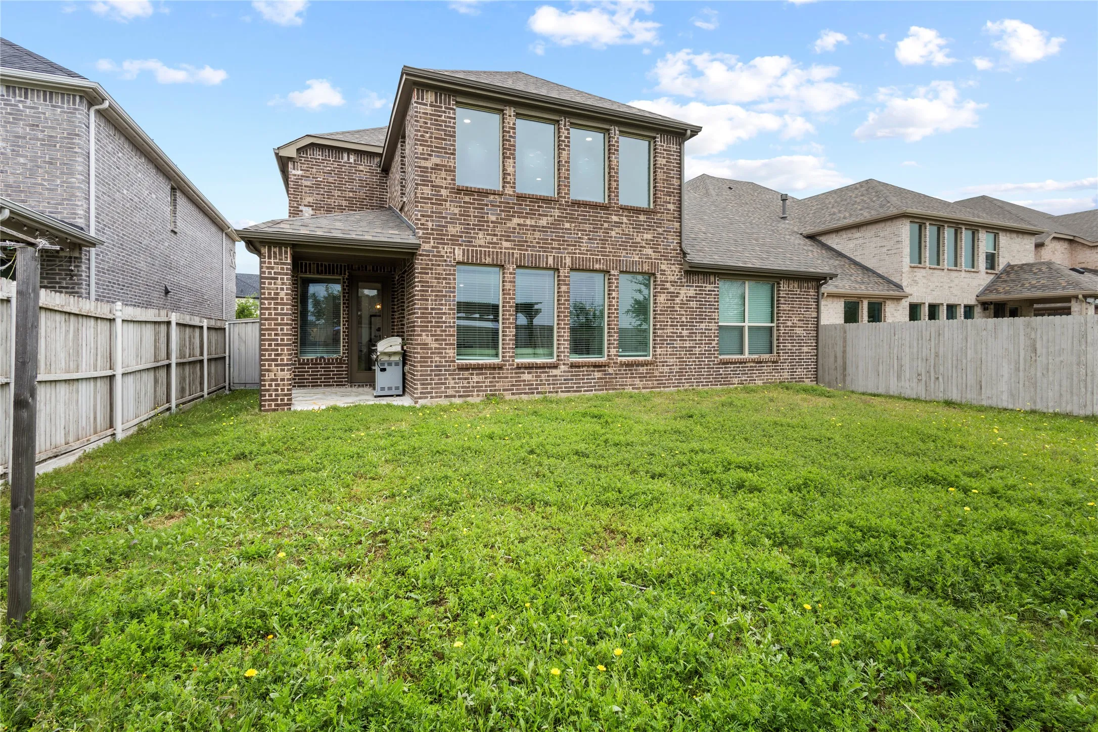 Expansive backyard with a brick and siding exterior