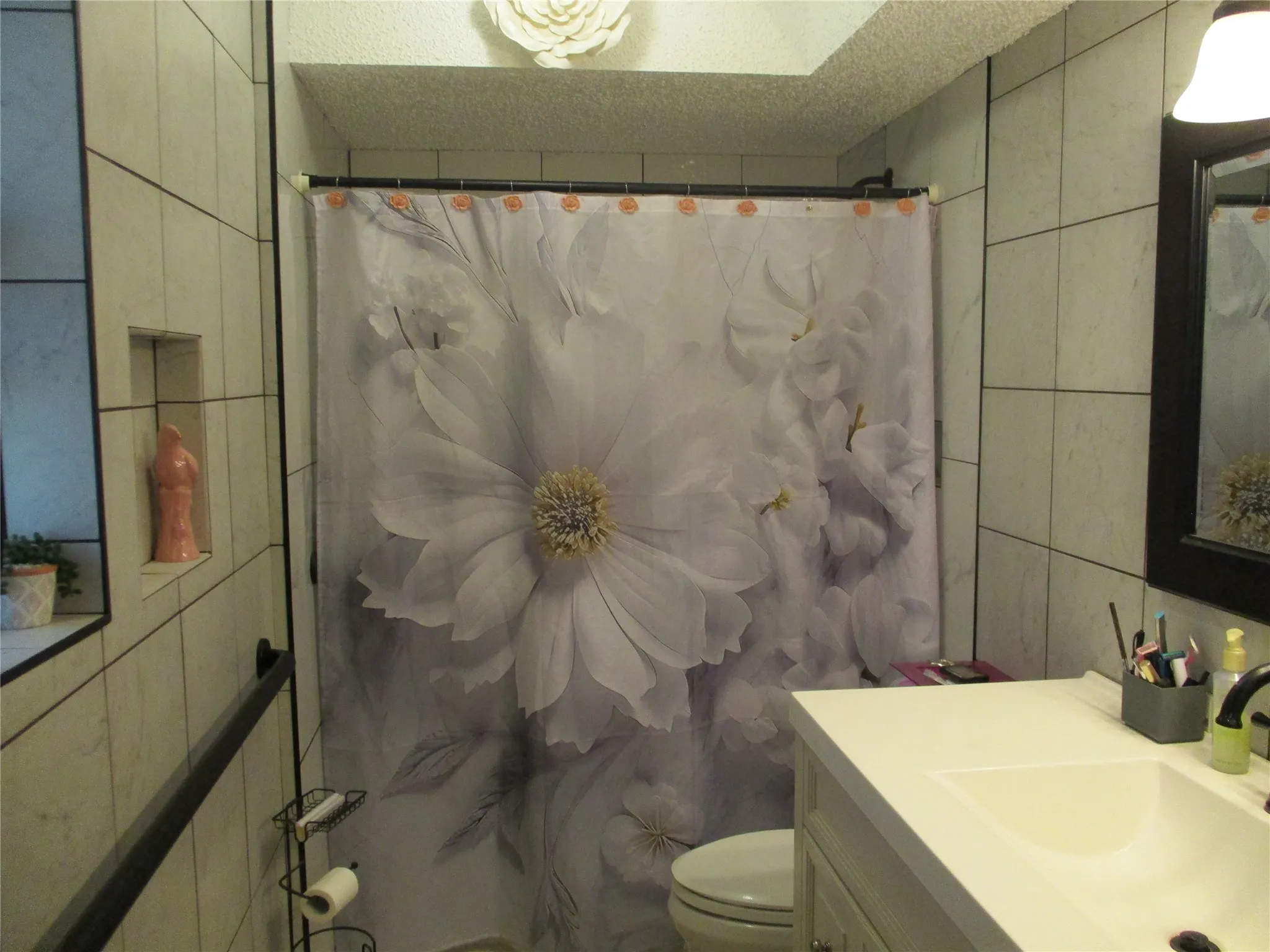 Completely tiled bathroom with a step-in shower, tall vanity and linen storage