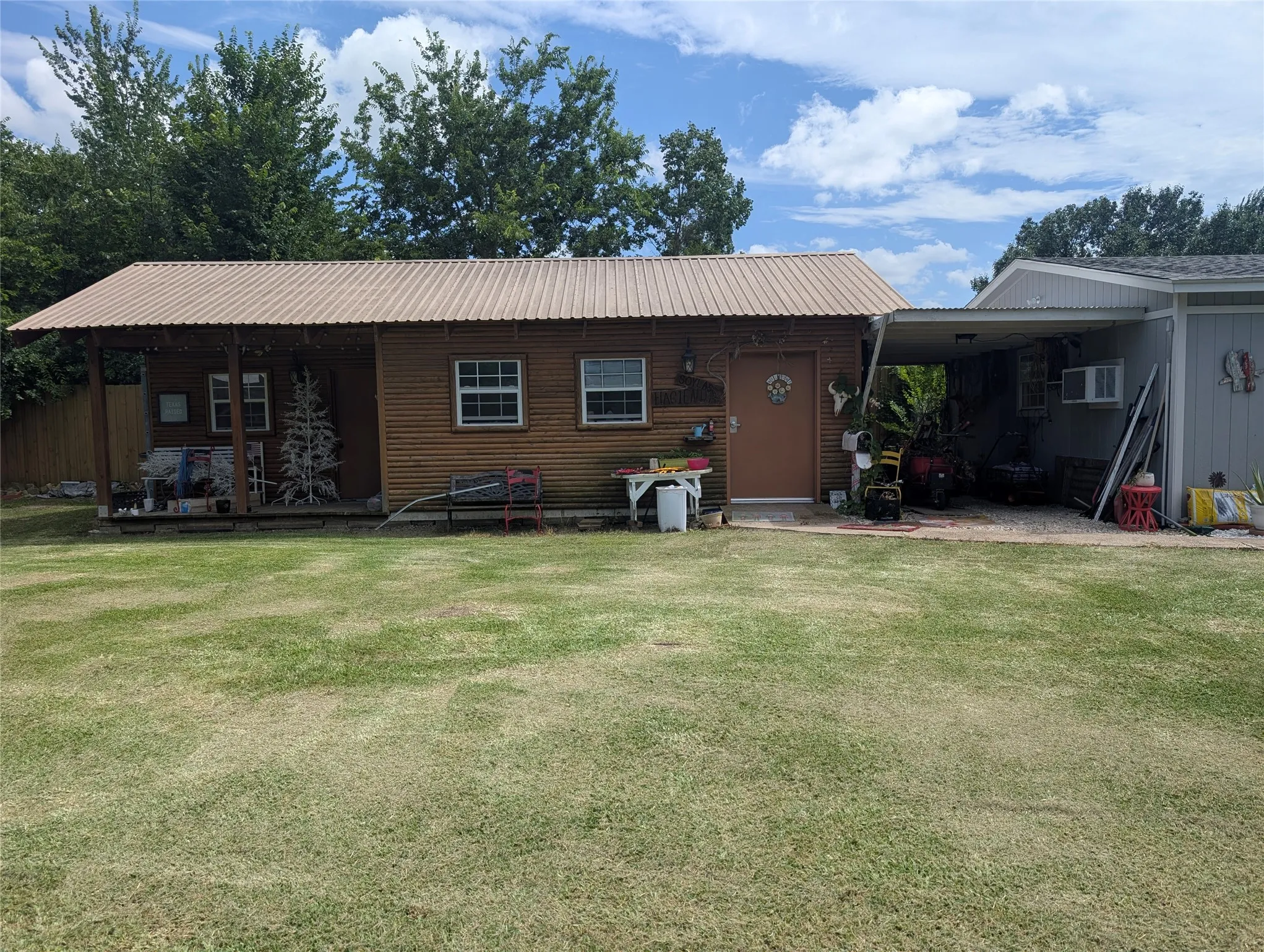 Seller calls this the "hacienda". It has two separate rooms.  Two entrances.  A porch to hang out on.  This could easily be an extra living space with a little work. Possibly an office space or hobby room.   It already has electricity and window units.
