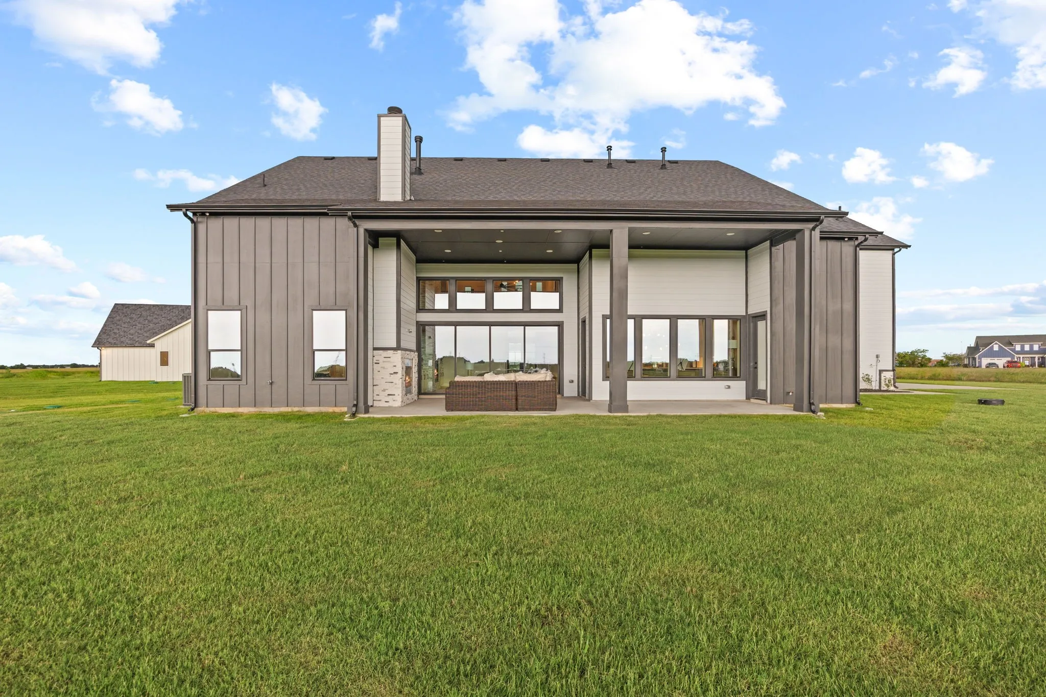 Rear exterior showcasing a covered patio with integrated fireplace