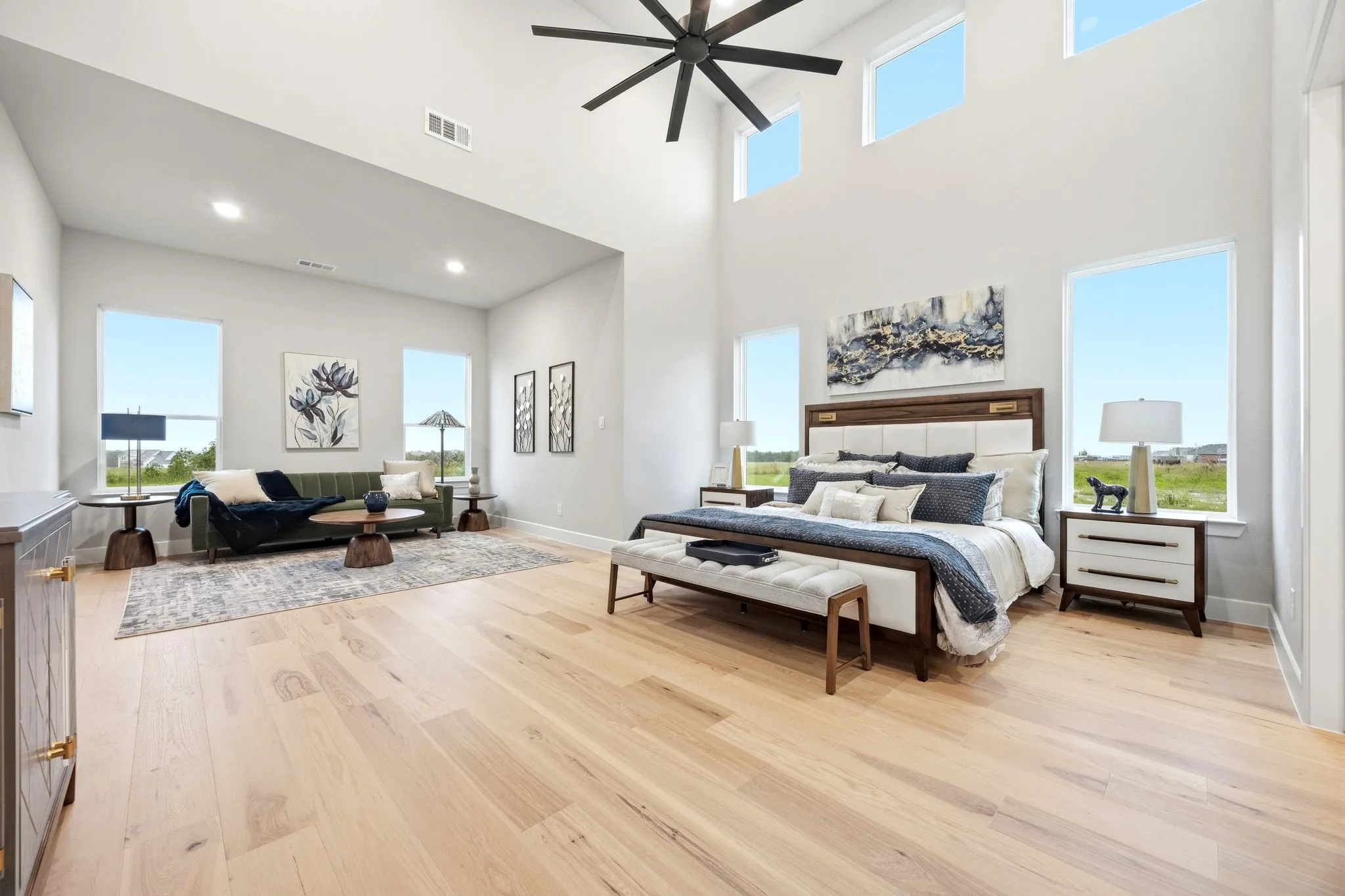 Vaulted ceilings with a ceiling fan, light wood-finish flooring, recessed lighting, and expansive windows