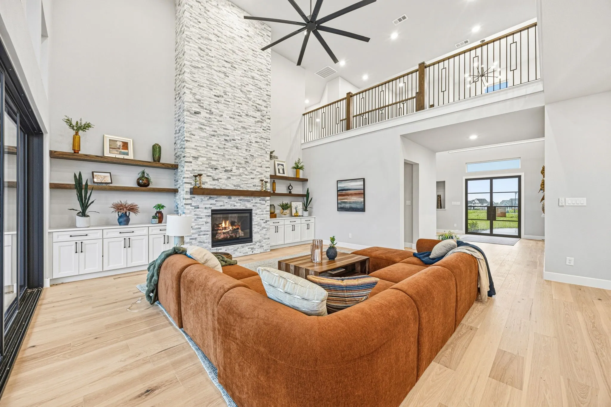 Soaring two-story living area with wood-finish flooring