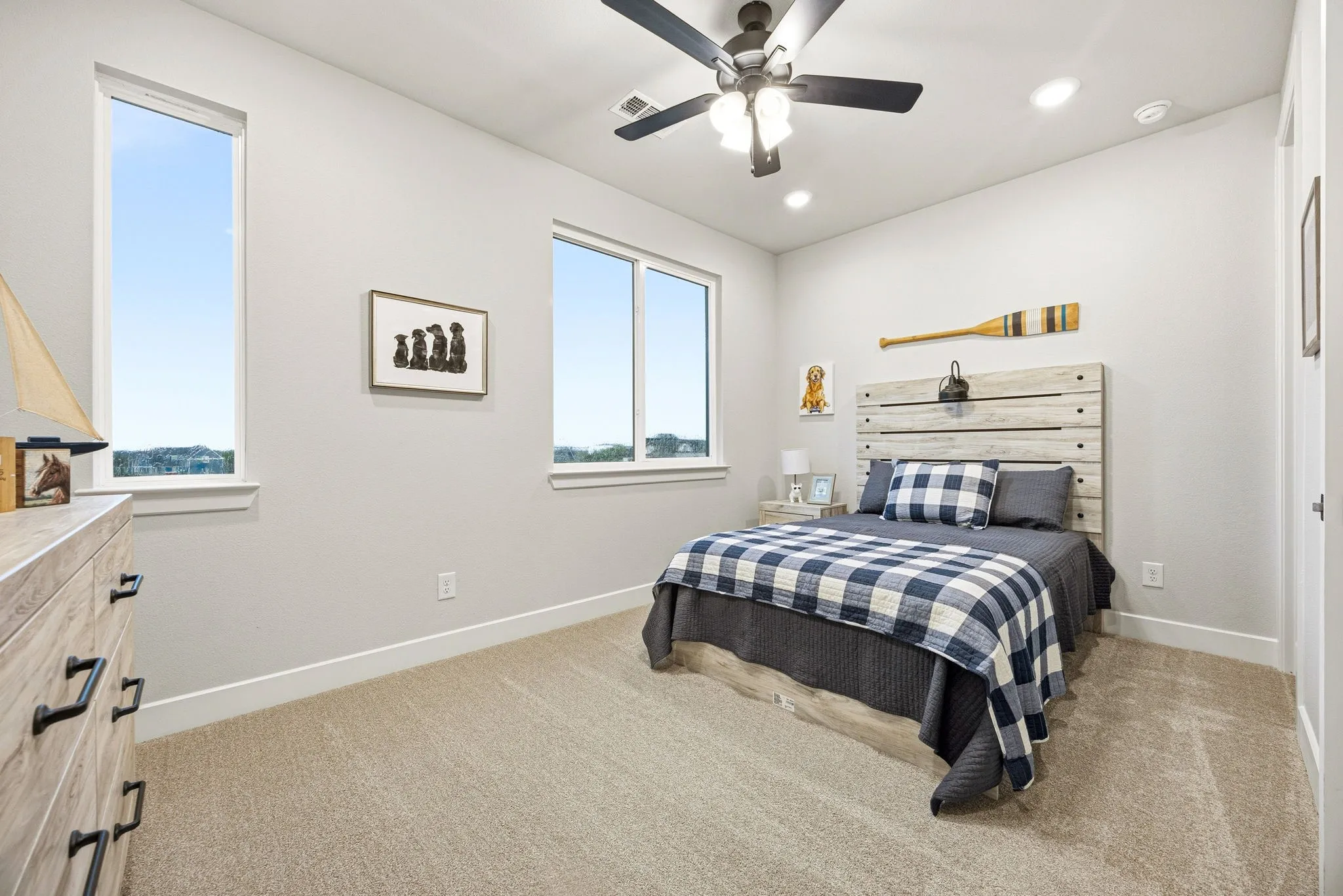 Bedroom featuring two large windows, neutral carpeting, a ceiling fan with integrated lighting, and recessed ceiling lights