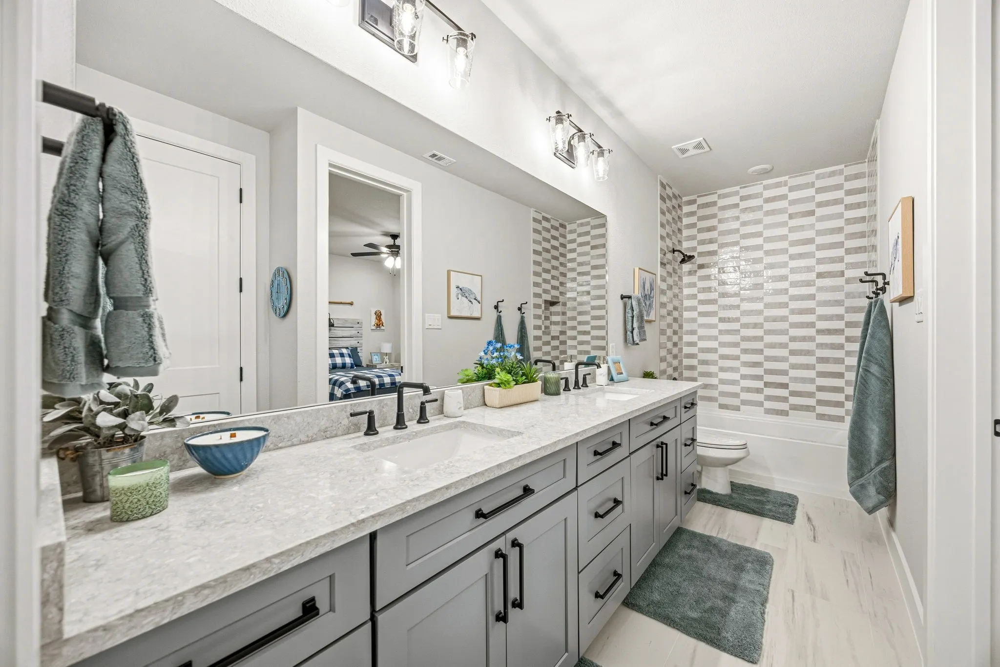 Dual vanity with light gray cabinetry and black hardware