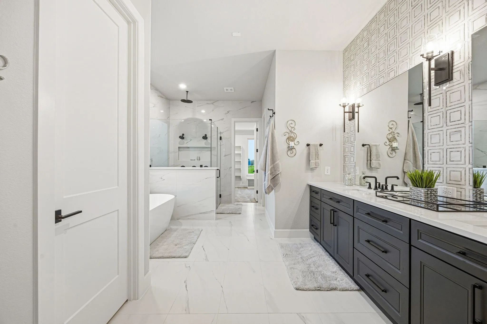 Spacious bathroom featuring a double vanity with dark cabinetry, dual mirrors, and contemporary sconce lighting