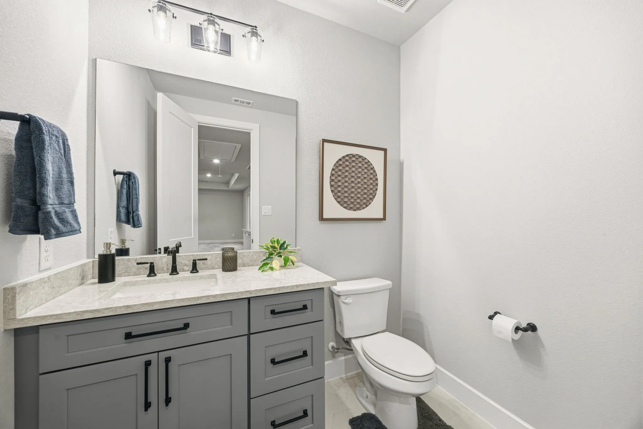 Vanity with gray cabinetry, a light-toned countertop, and a rectangular undermount sink