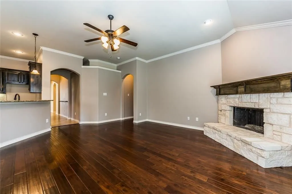 Living room with cool fireplace and nice fan&light fixture, wood floor.