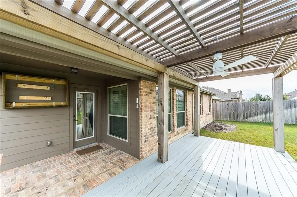 Covered porch with extended patio and pergola on it.