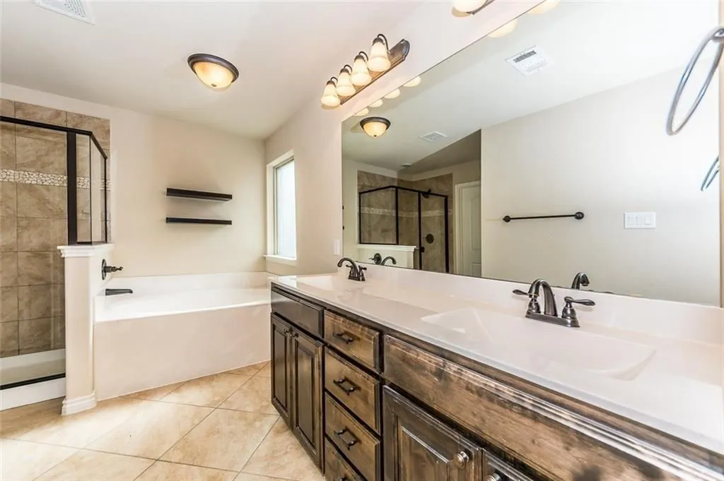 Featuring double vanity and a garden tub, separate shower.