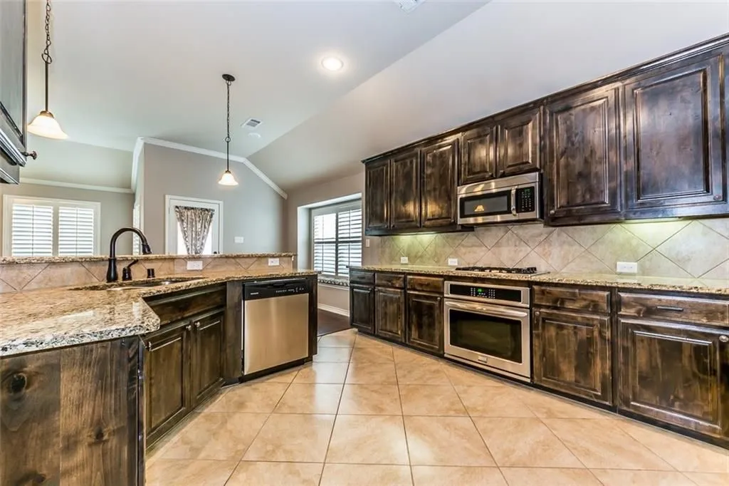 Kitchen featuring stainless steel appliances and lots of cabinet space and granite countertop.
