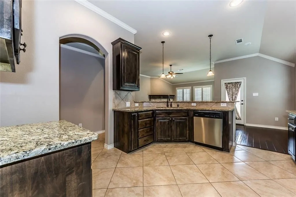 Kitchen with double bowl sink and SS dishwasher, connecting the breakfast area.