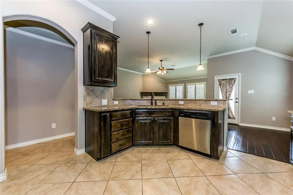 Kitchen with the kitchen sink facing open space of family room and breakfast area.