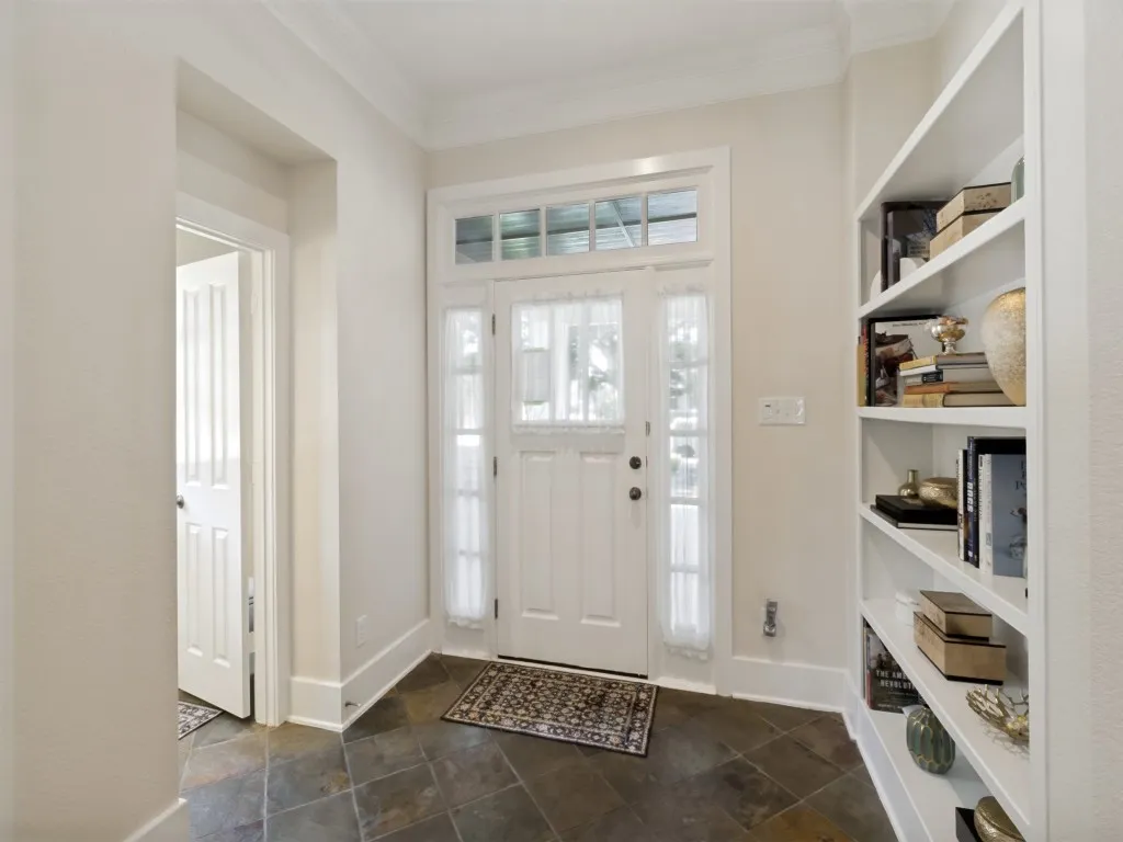 foyer with shelving and entrance to half bath