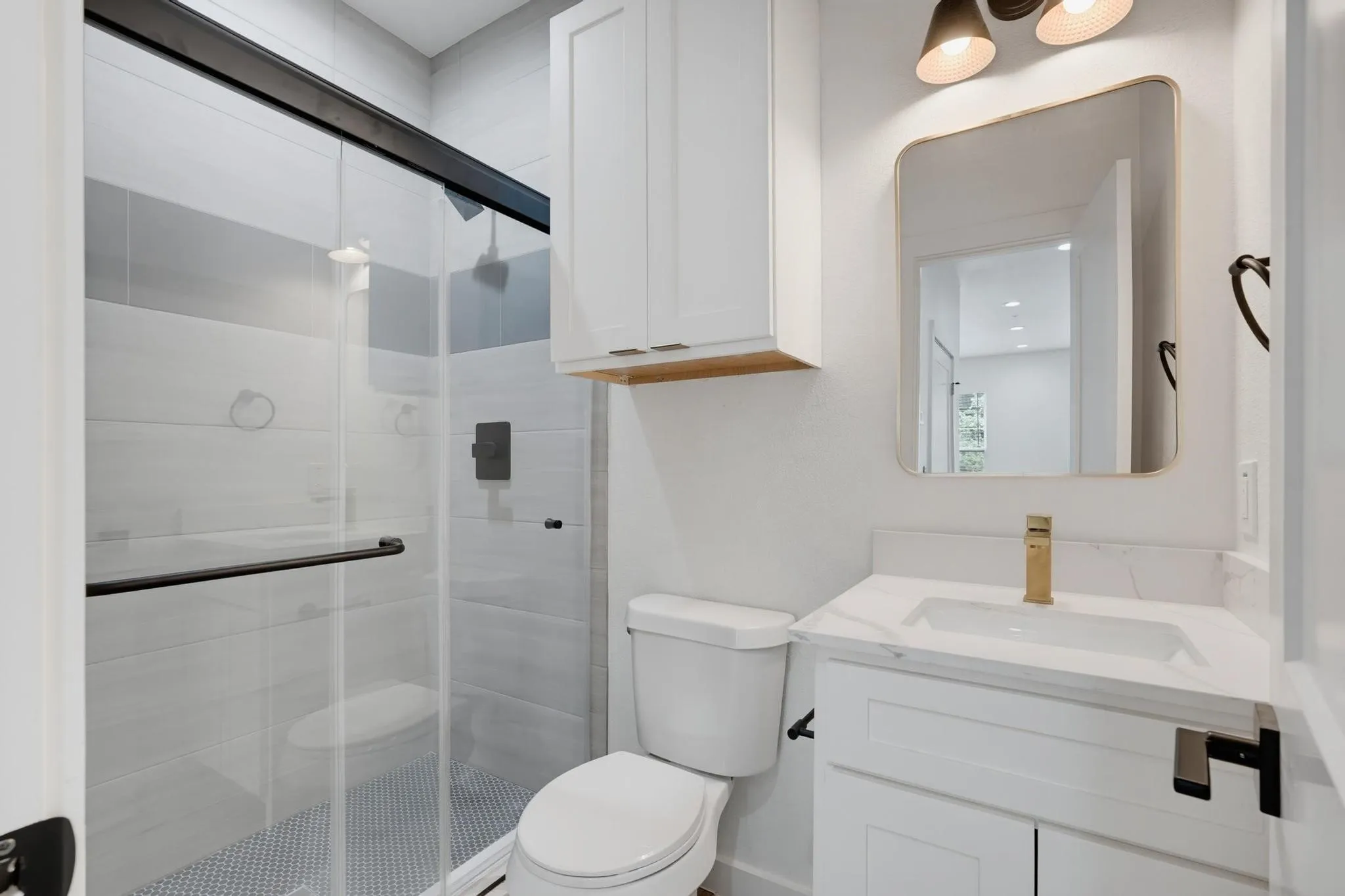 Contemporary bathroom featuring a glass-enclosed shower with subway tile surround and a penny tile floor