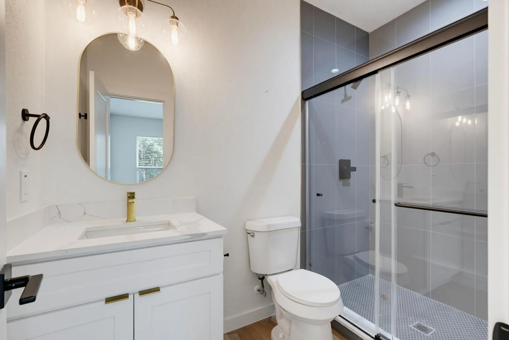Bathroom featuring a white vanity with gold hardware, a rectangular undermount sink, and a white countertop