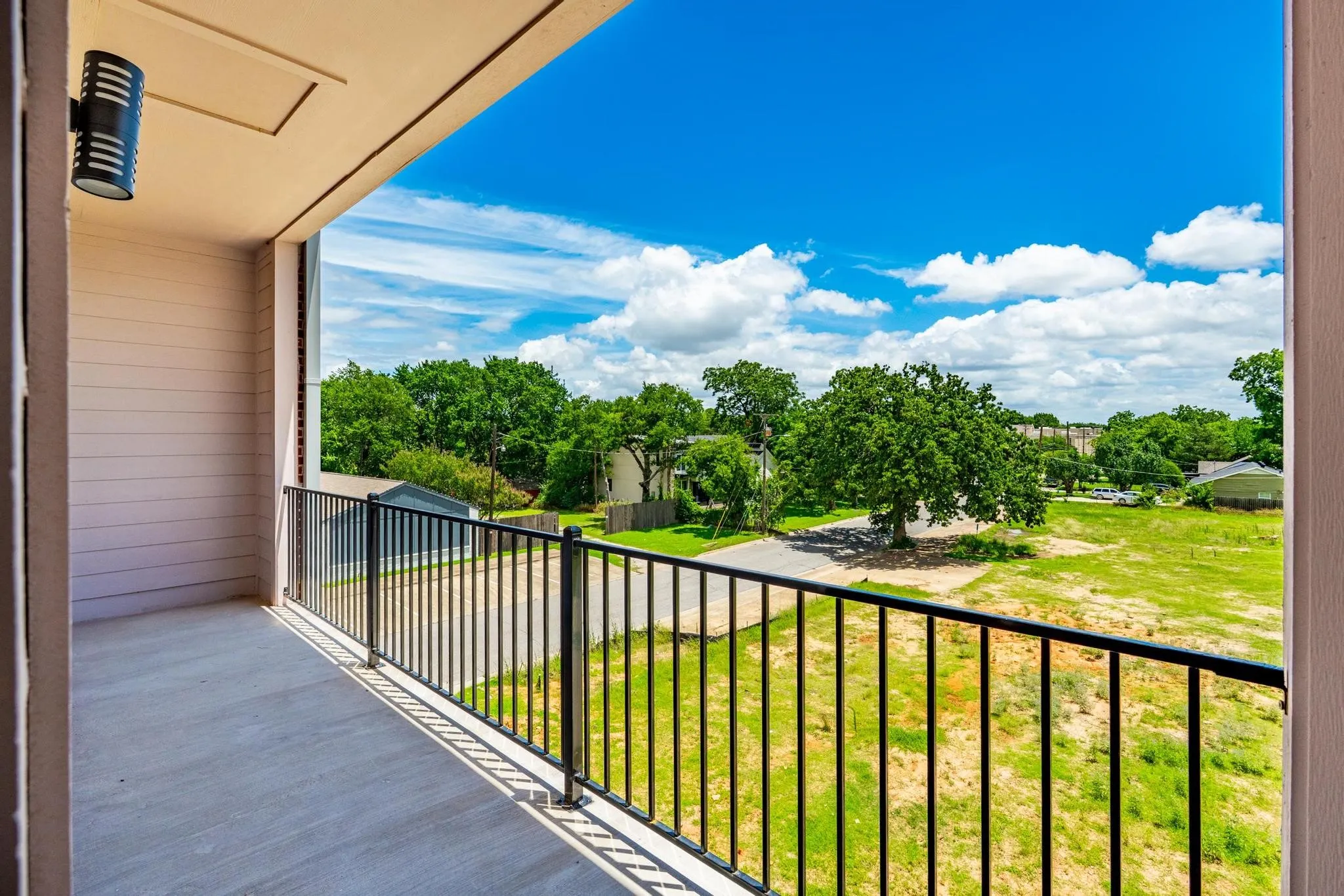 Private balcony featuring a concrete floor and black metal railings