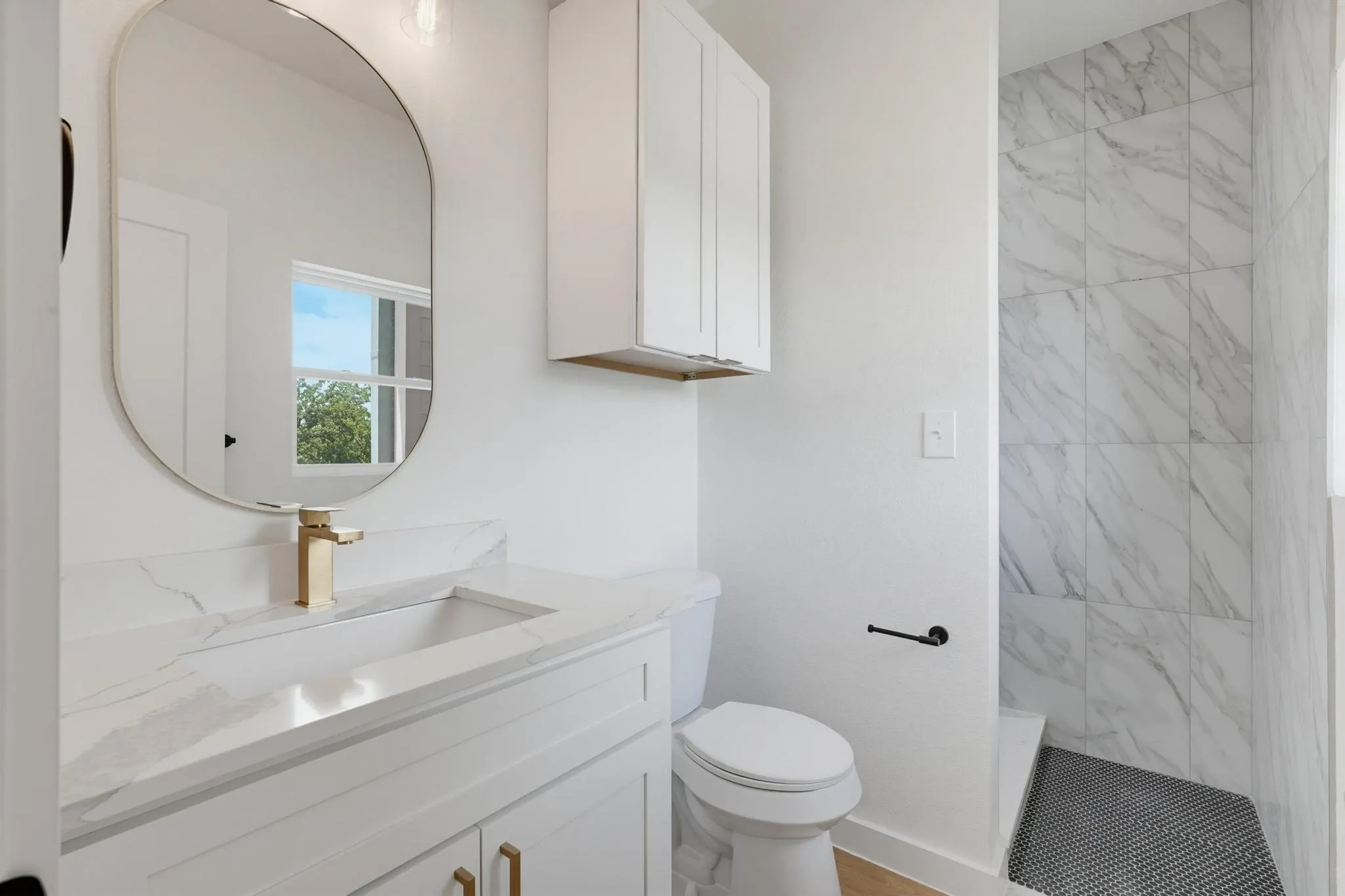 Bathroom featuring a vanity with an integrated sink, gold-tone faucet, and white countertop