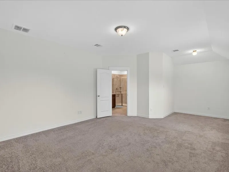 Spacious room featuring neutral carpeting and white walls