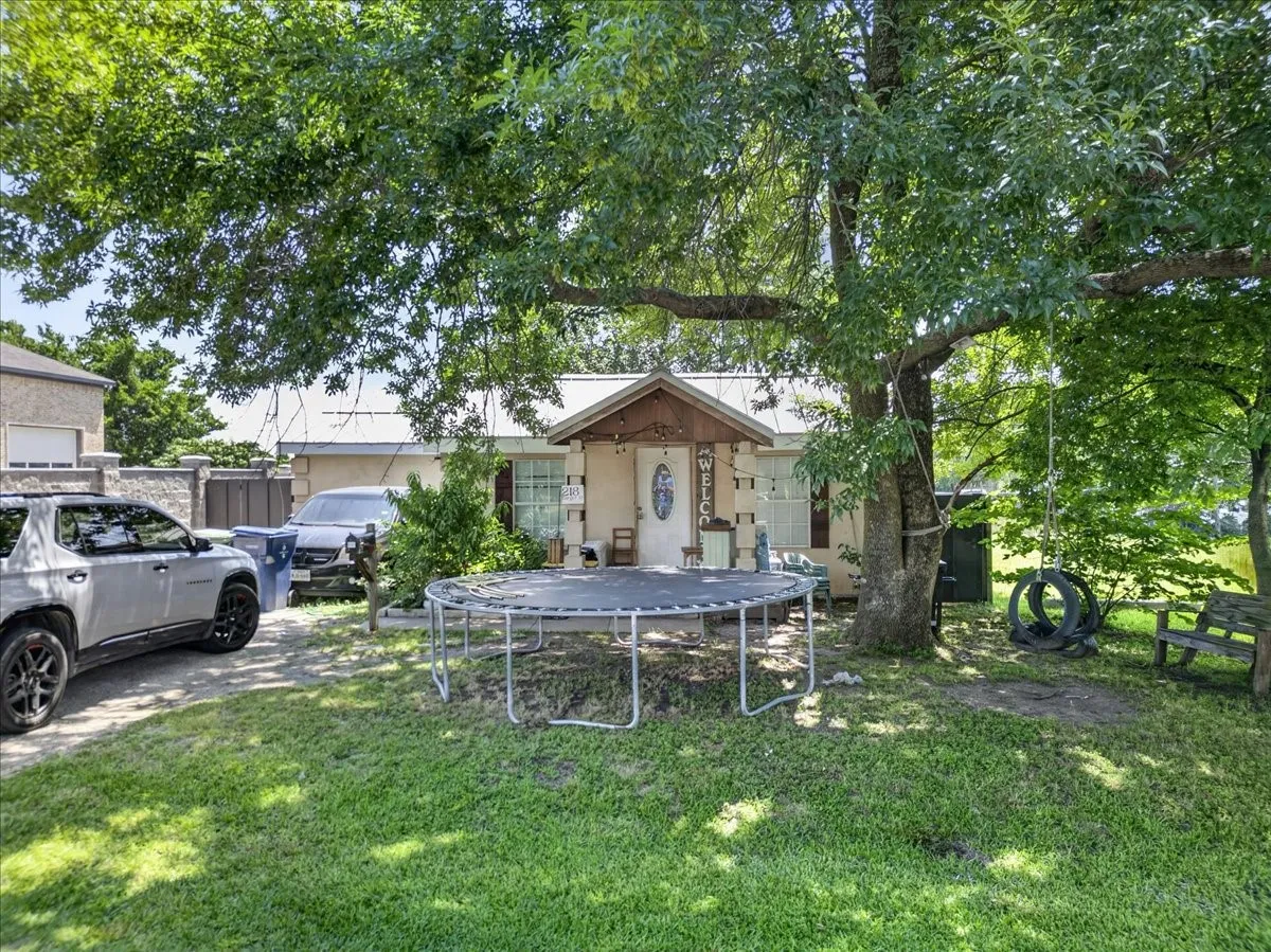 Single-story residence featuring a covered front porch and a prominent mature tree