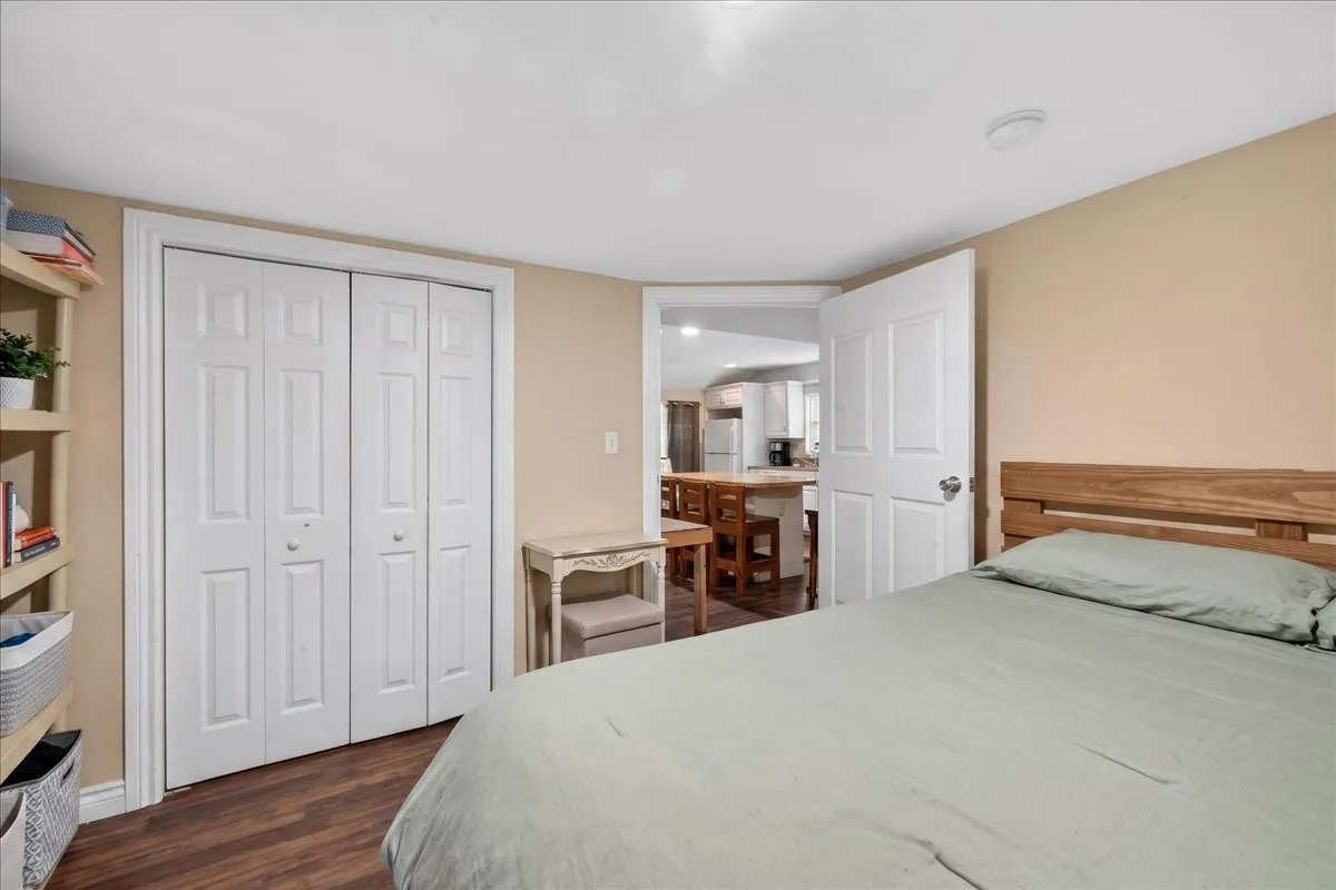 Bedroom featuring wood-finish flooring, a white bi-fold closet, and neutral wall paint