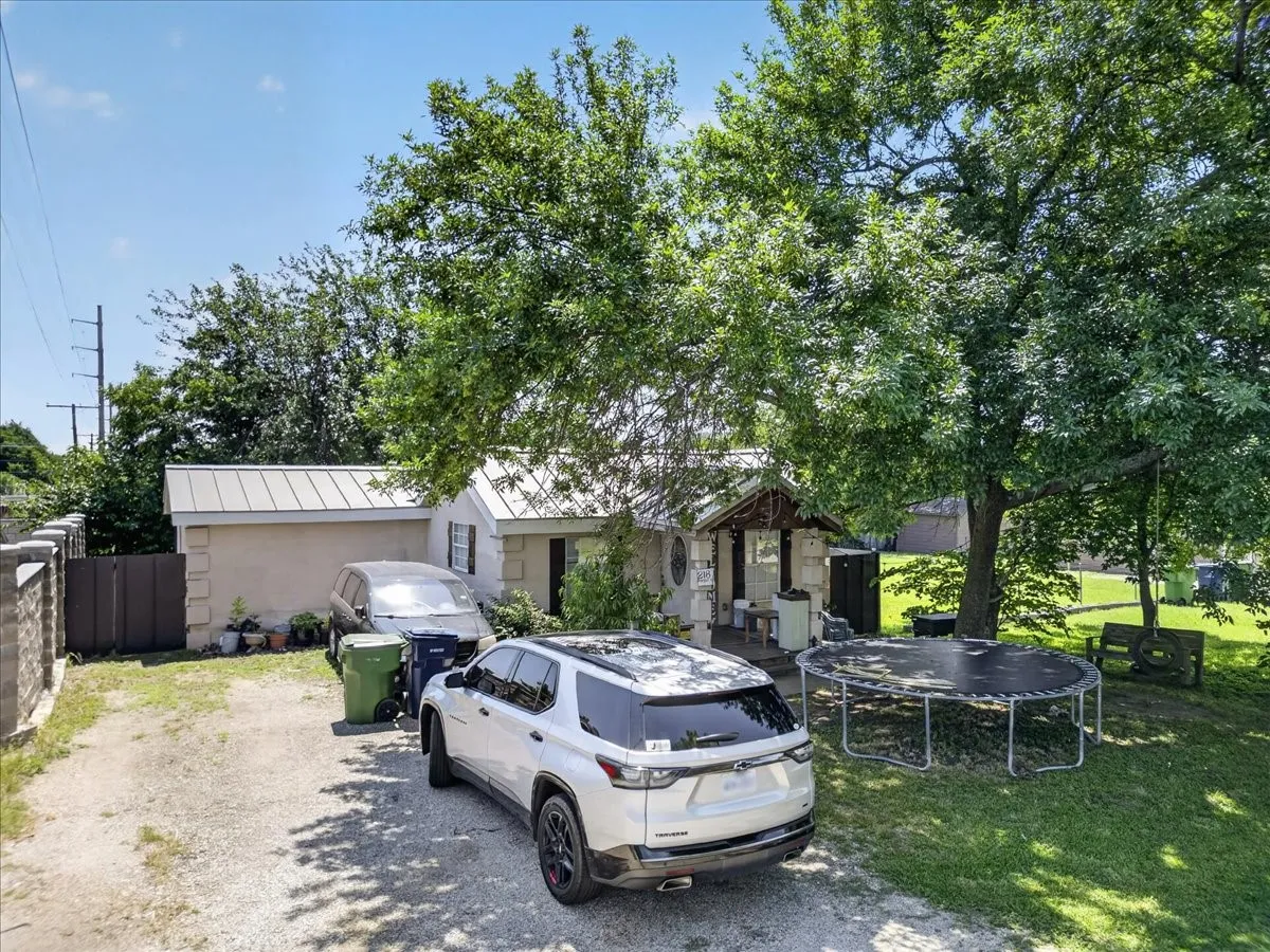 Gravel driveway providing off-street parking, accompanied by a detached garage with a metal roof