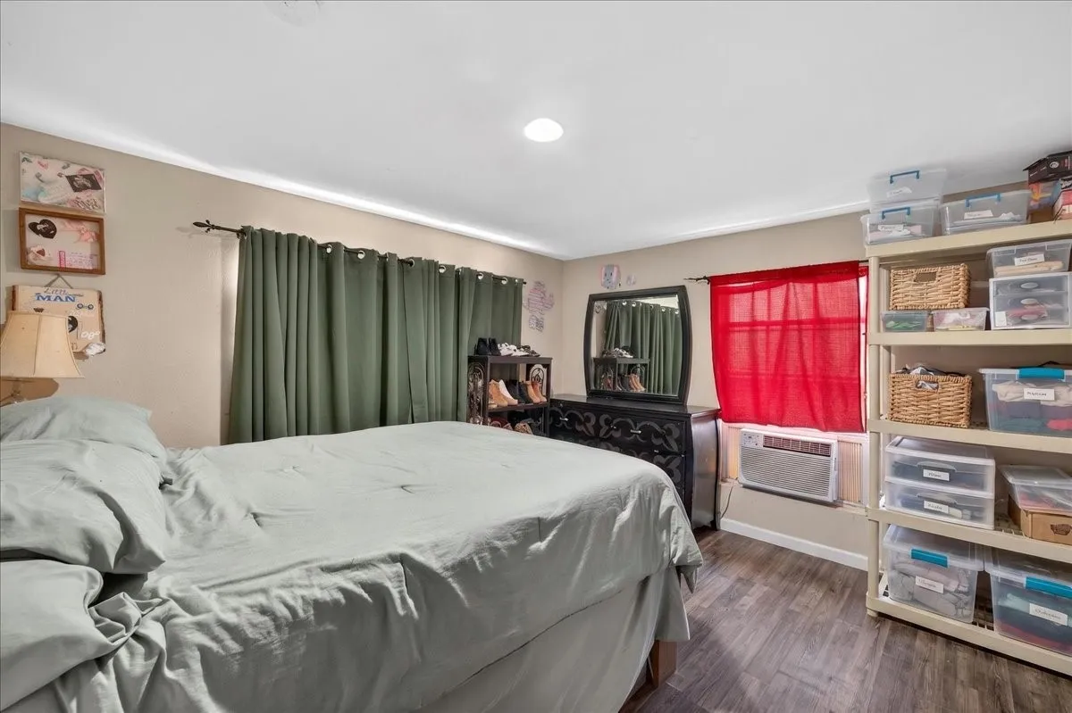 Spacious room featuring wood-finish flooring, neutral-toned walls, and recessed ceiling lighting