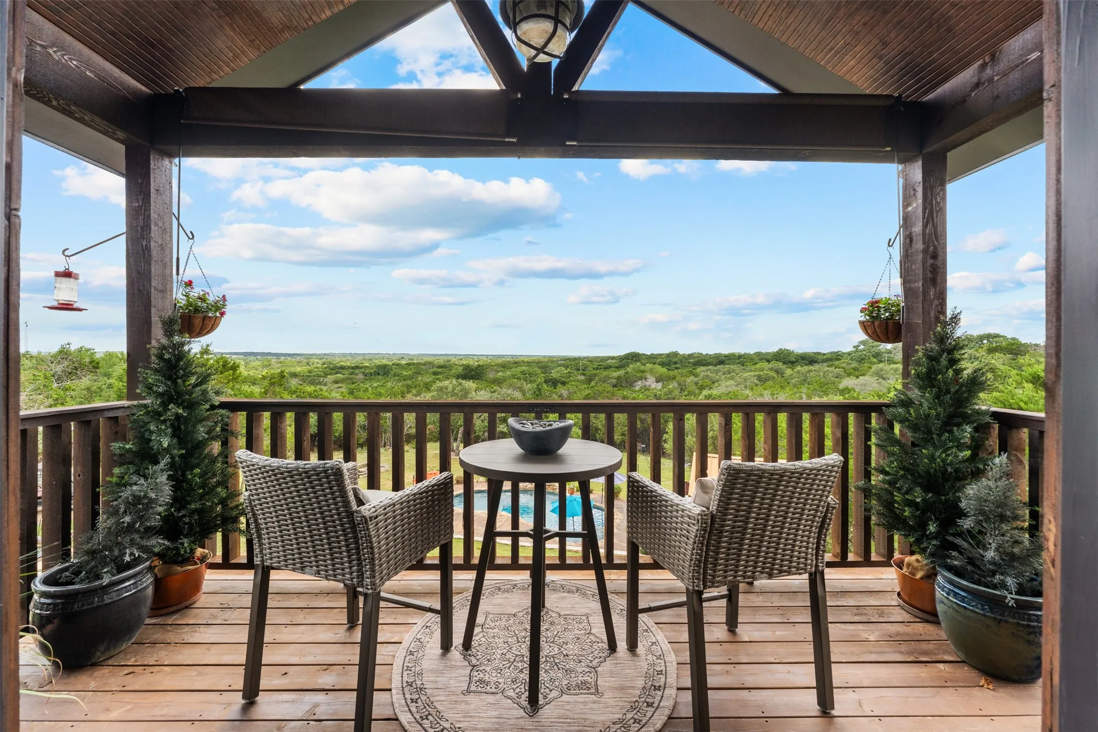 Balcony off Primary bedroom featuring a wood-finish deck and ceiling, exposed structural beams, and traditional railing