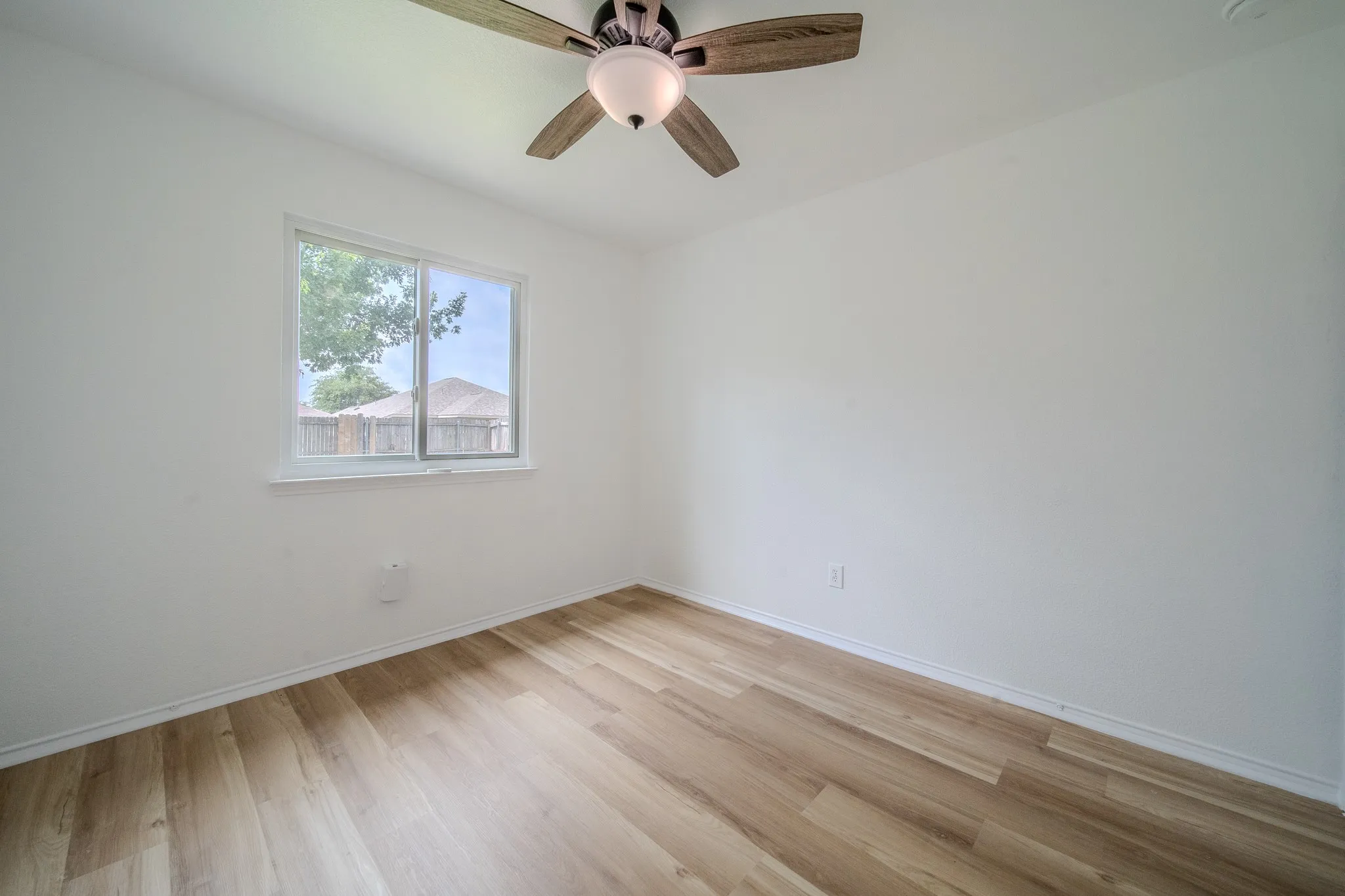 Interior space featuring light wood-finish flooring, white walls, and a white trim
